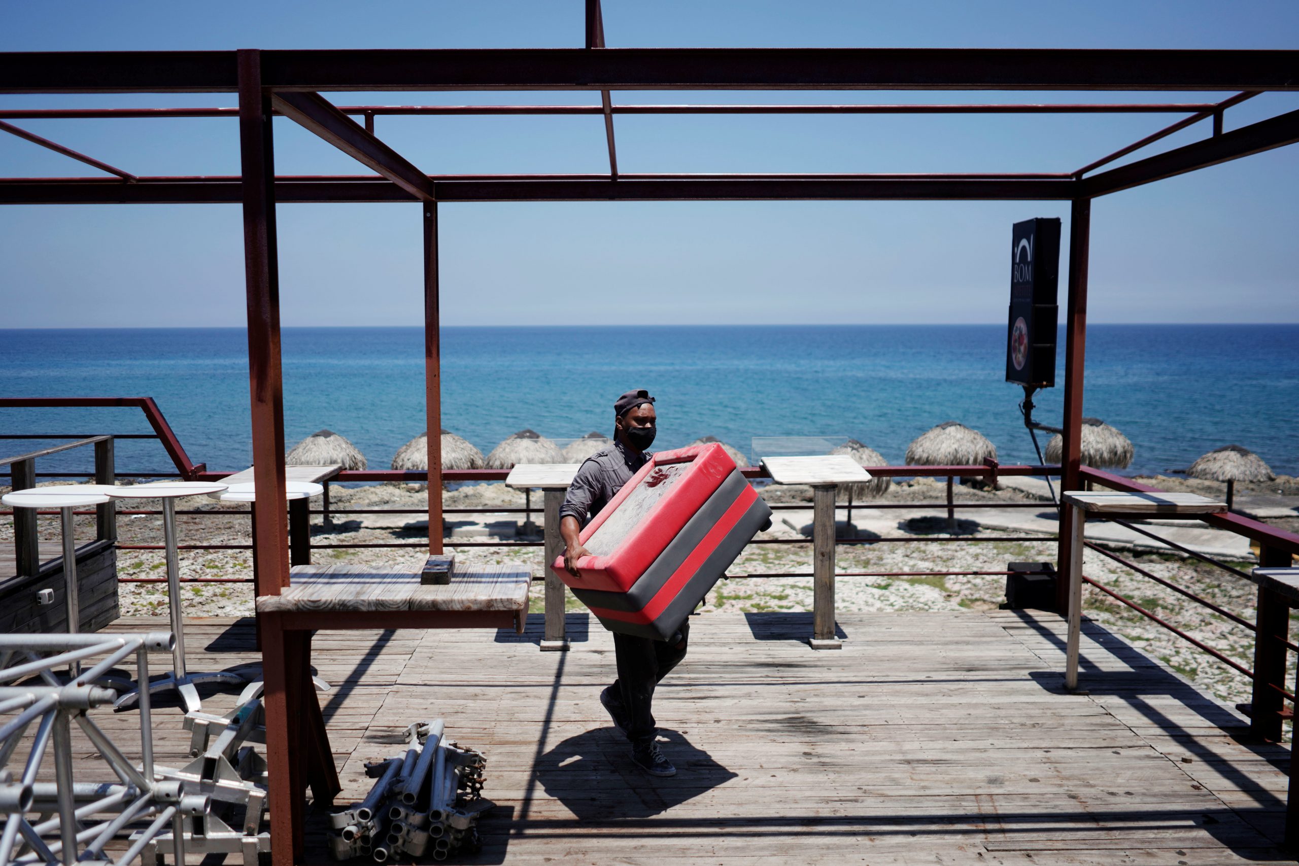 A worker removes furniture from a restaurant terrace as Storm Elsa approaches the island, in Havana, Cuba, July 3, 2021. REUTERS/Alexandre Meneghini