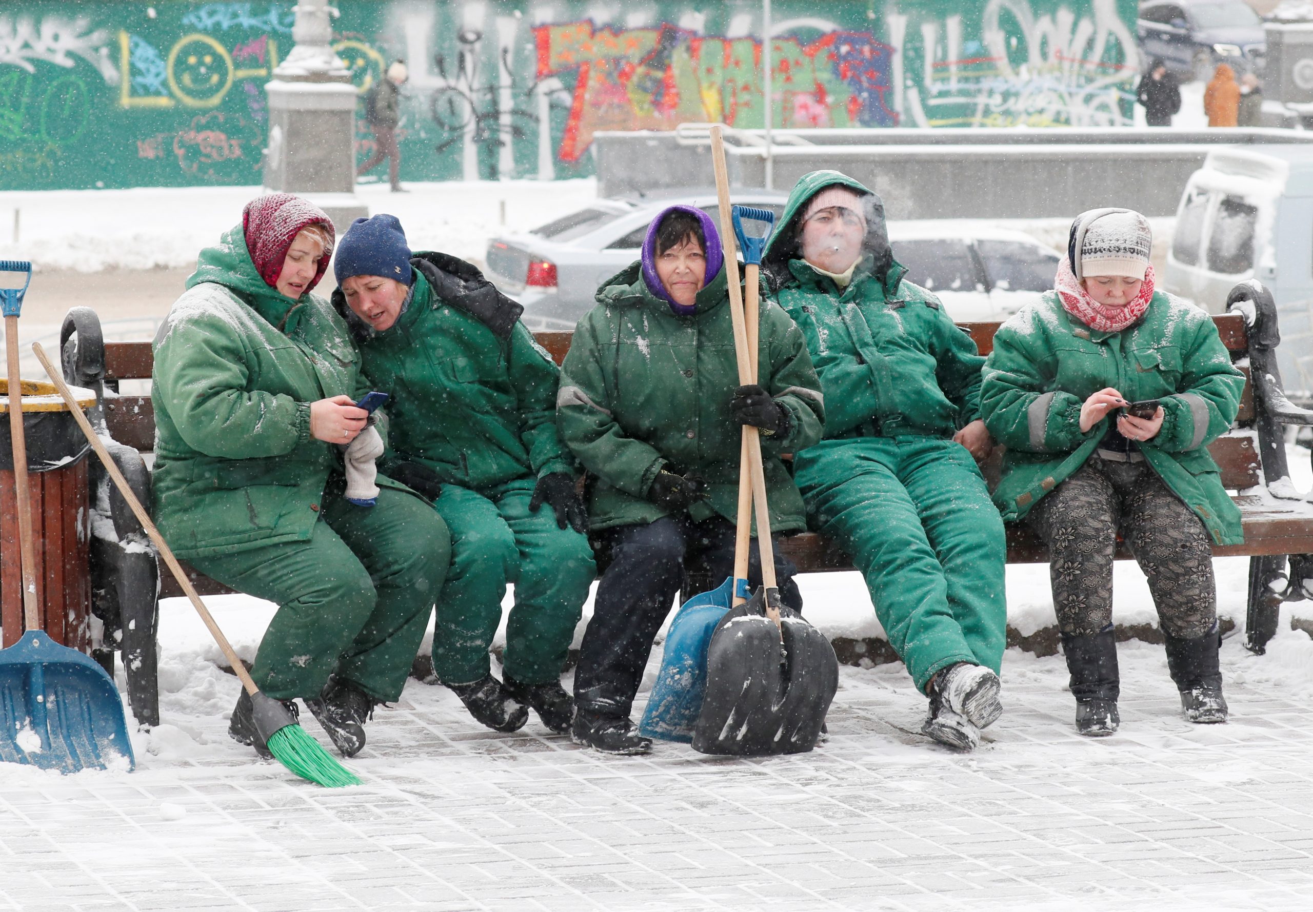 Municipal workers rest as they remove snow during  snowfall in central Kyiv, Ukraine February 8, 2021.  REUTERS/Gleb Garanich