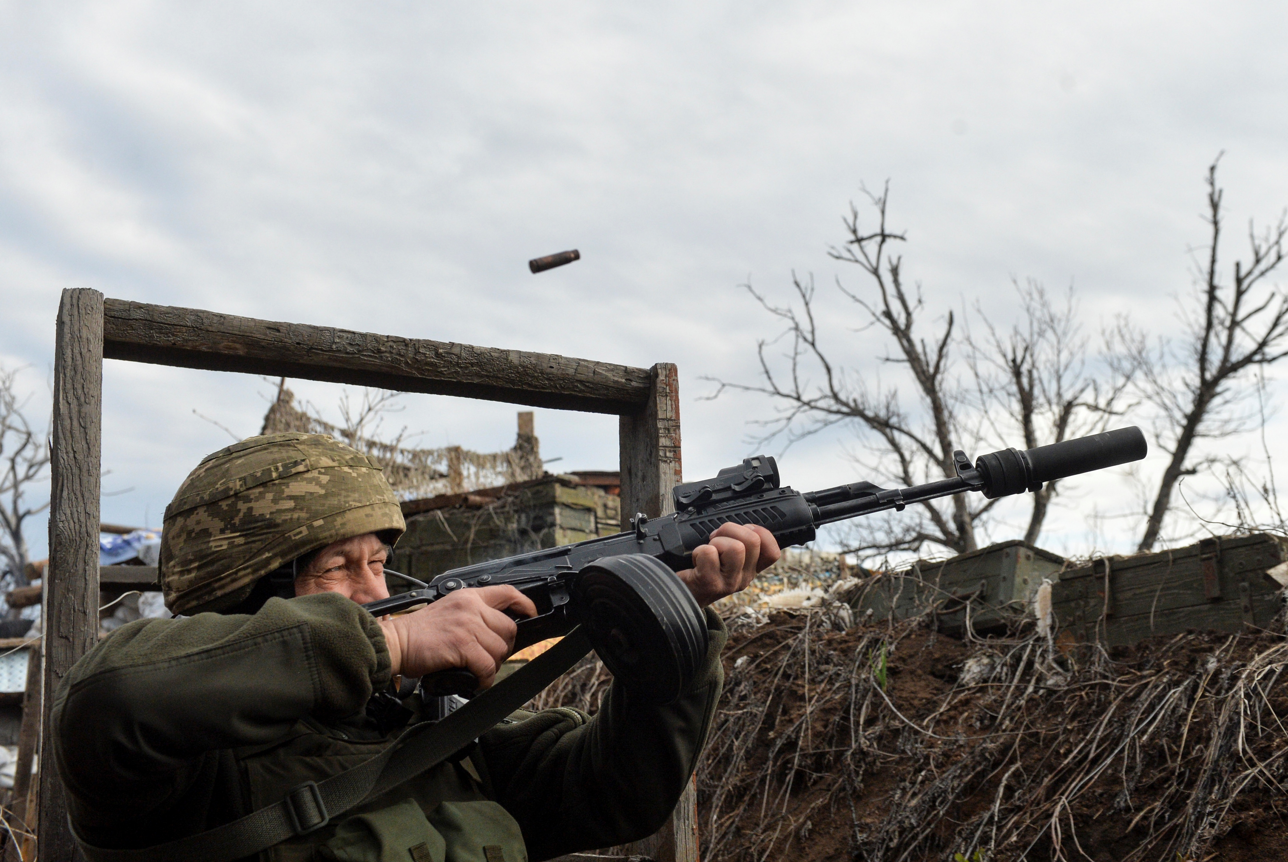 A service member of the Ukrainian armed forces fires at fighting positions near Donetsk