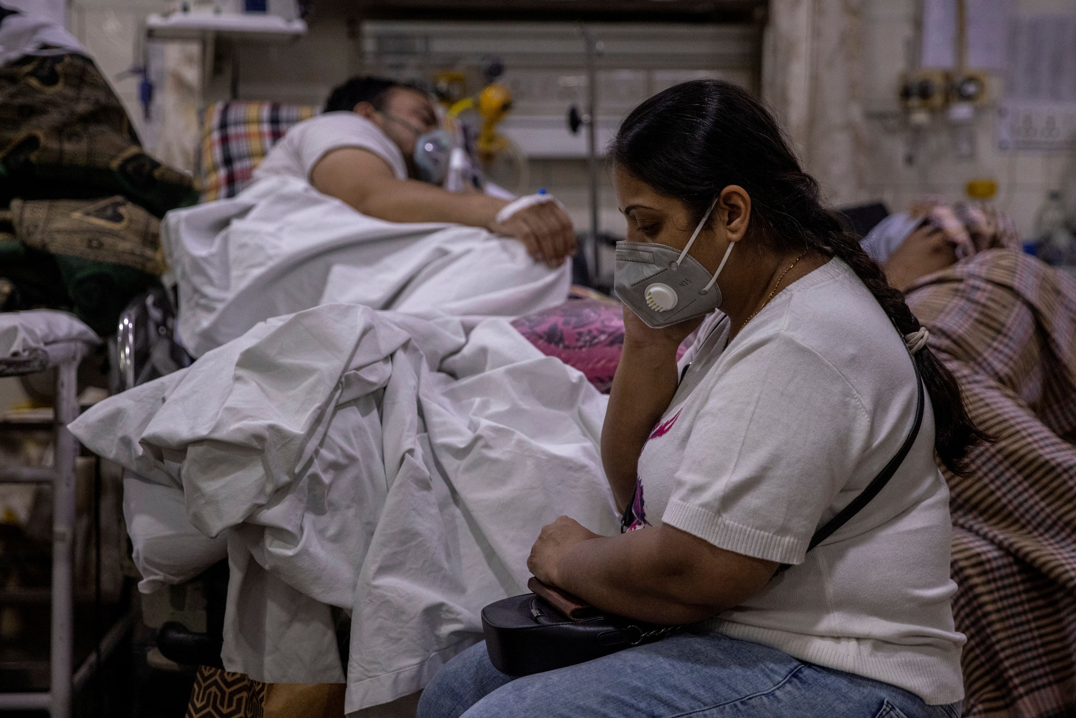 Manika Goel, sits next to her husband who is suffering from the coronavirus disease (COVID-19) inside the emergency ward at Holy Family hospital in New Delhi, India, April 29, 2021. REUTERS/Danish Siddiqui