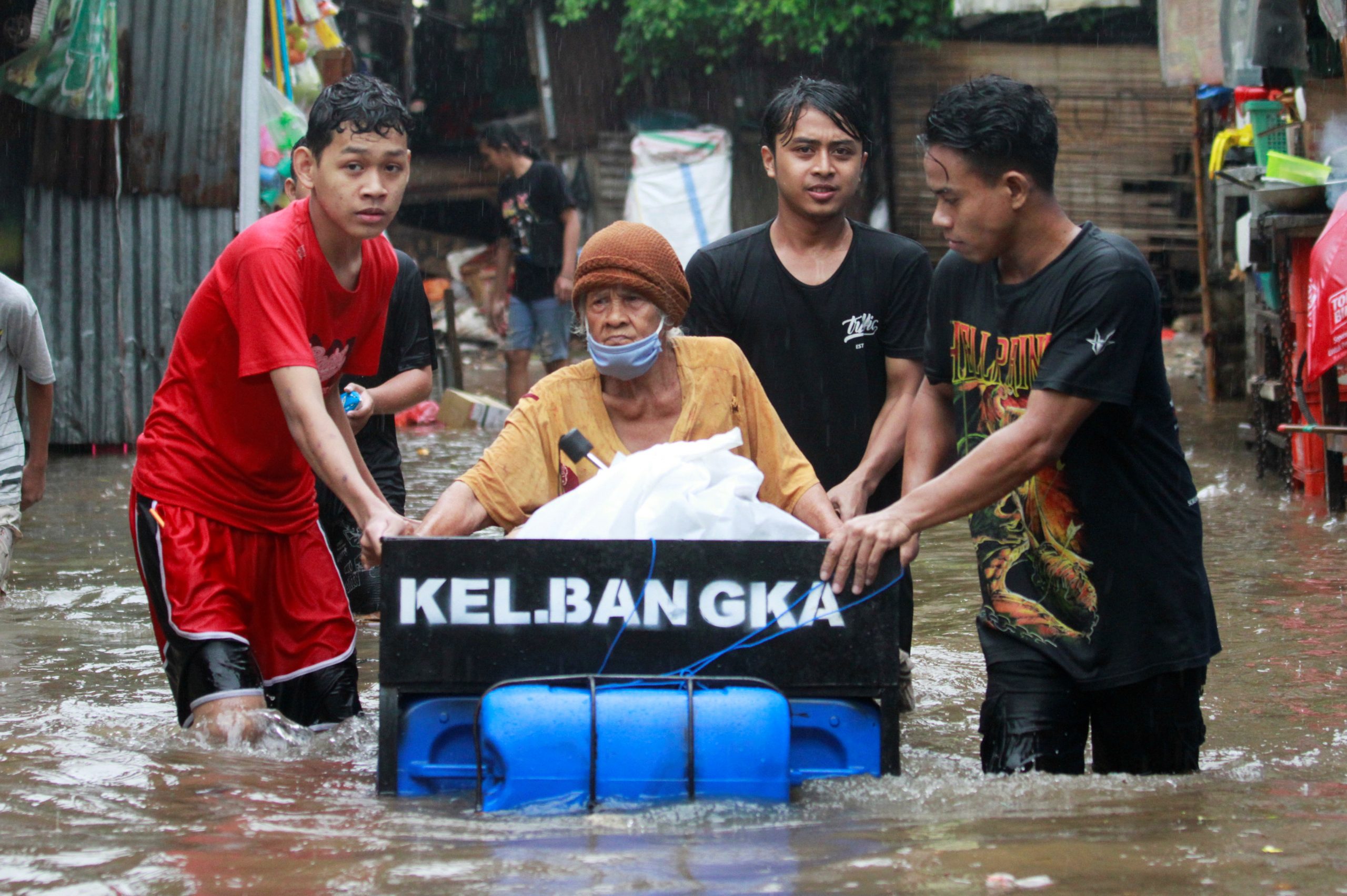 18022021 Youths transport an elderly woman using a makeshift raft in an area affected by floods following heavy rains in Jakarta, Indonesia, February 18, 2021. REUTERS/Ajeng Dinar Ulfiana