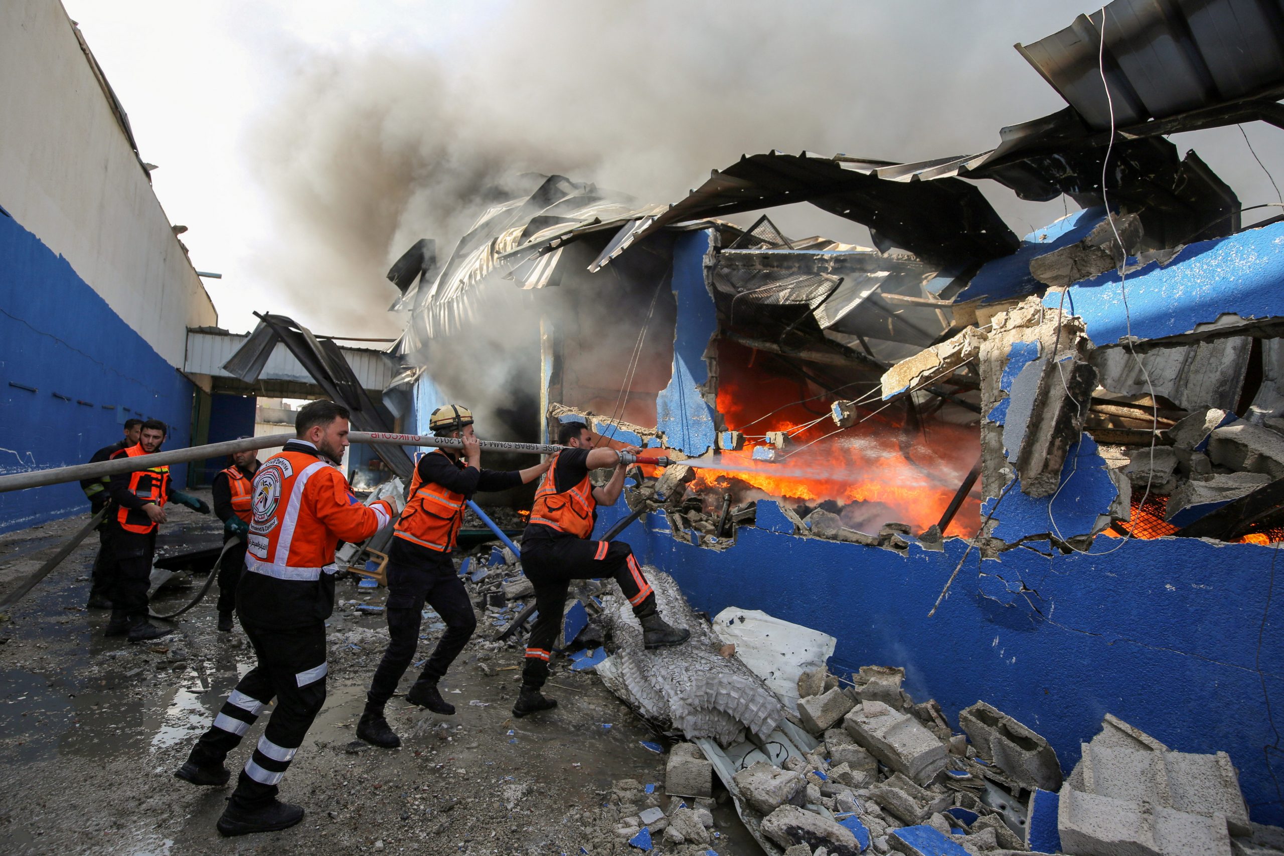 Palestinian firefighters participate in efforts to put out a fire at a sponge factory after it was hit by Israeli artillery shells, according to witnesses, in the northern Gaza Strip May 17, 2021. REUTERS/Ashraf Abu Amrah NO RESALES. NO ARCHIVES.