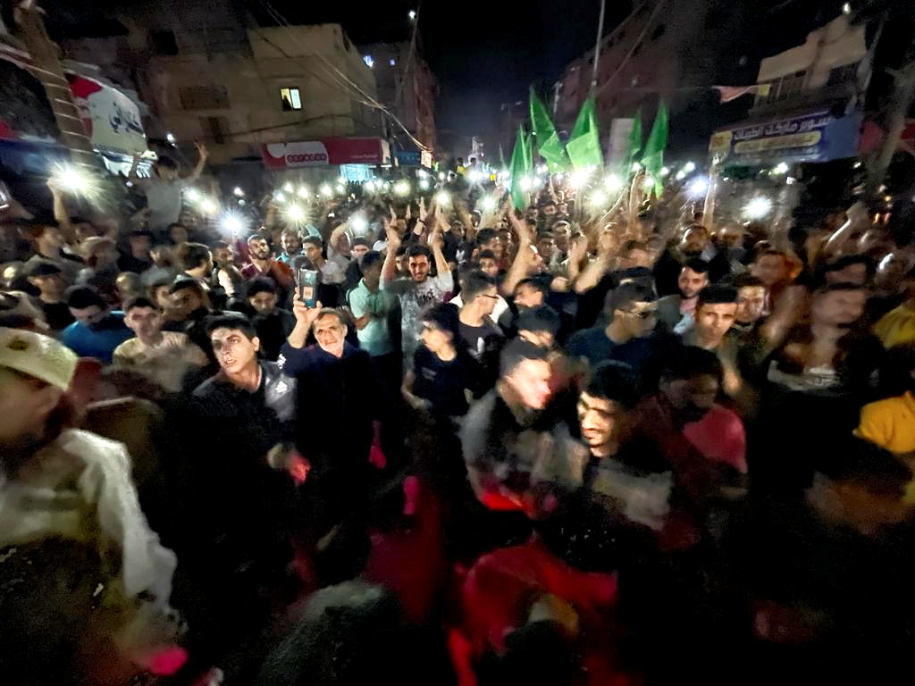 Palestinians celebrate in the streets following a ceasefire, in the southern Gaza Strip May 21, 2021. REUTERS/Ibraheem Abu Mustafa