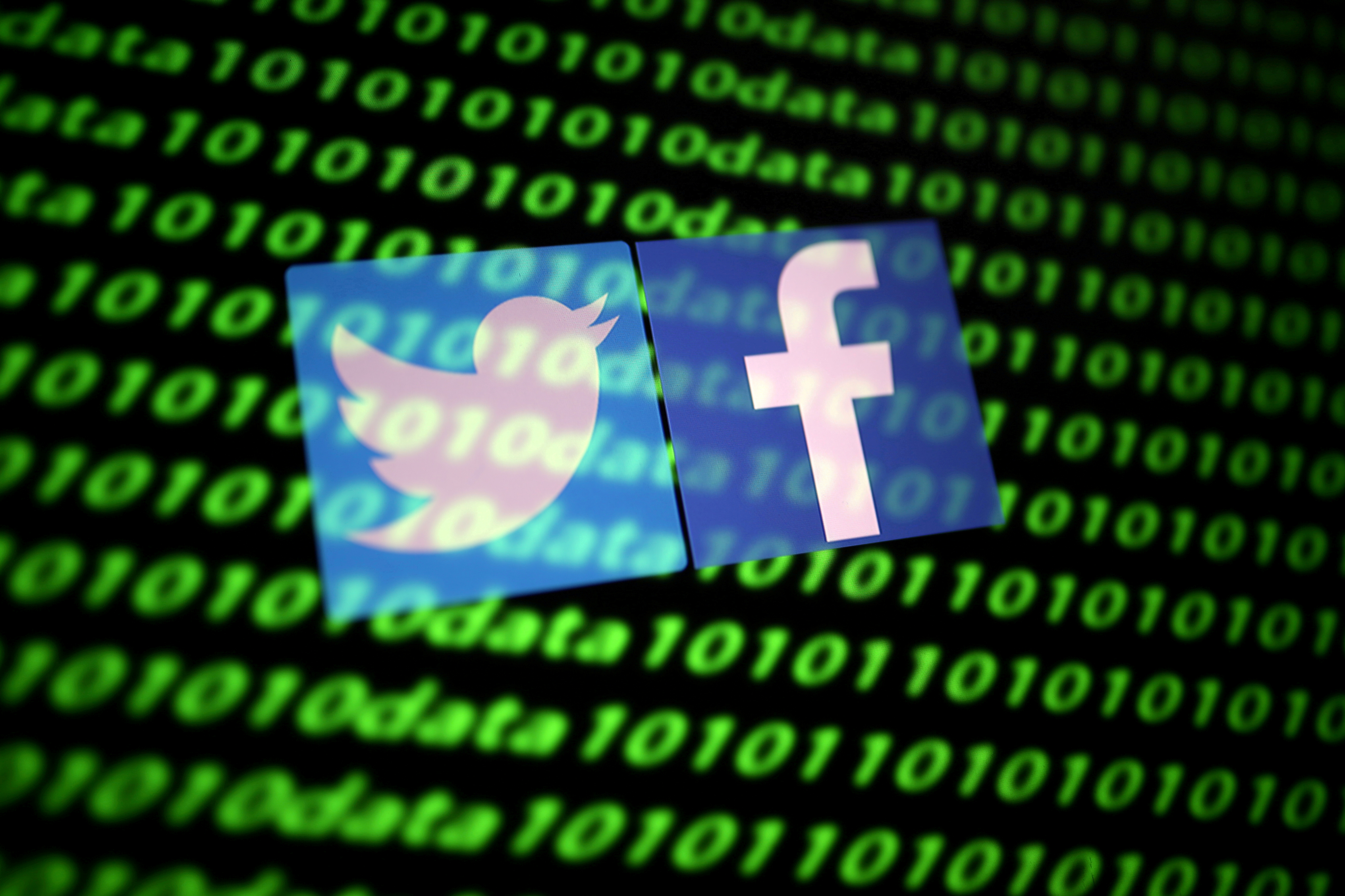 FILE PHOTO: The Twitter and Facebook logos along with binary cyber codes are seen in this illustration taken November 26, 2019. REUTERS/Dado Ruvic/Illustration/File Photo