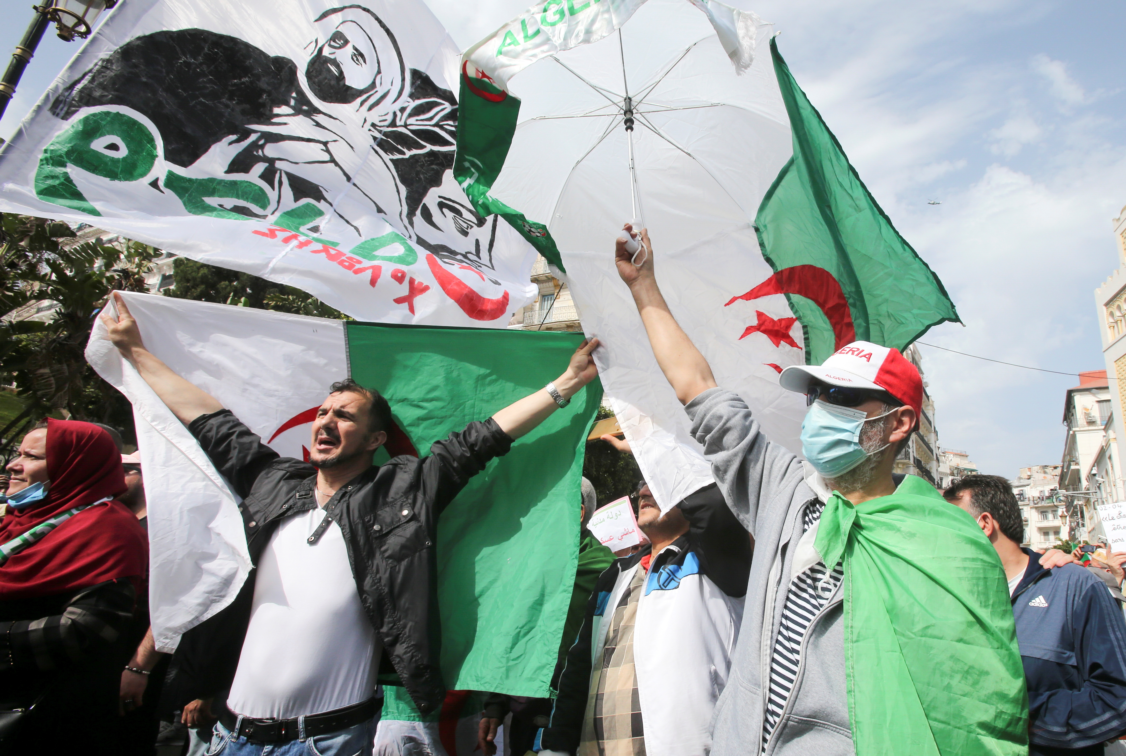 A demonstrator holds a national flag during a protest demanding political change, in Algiers