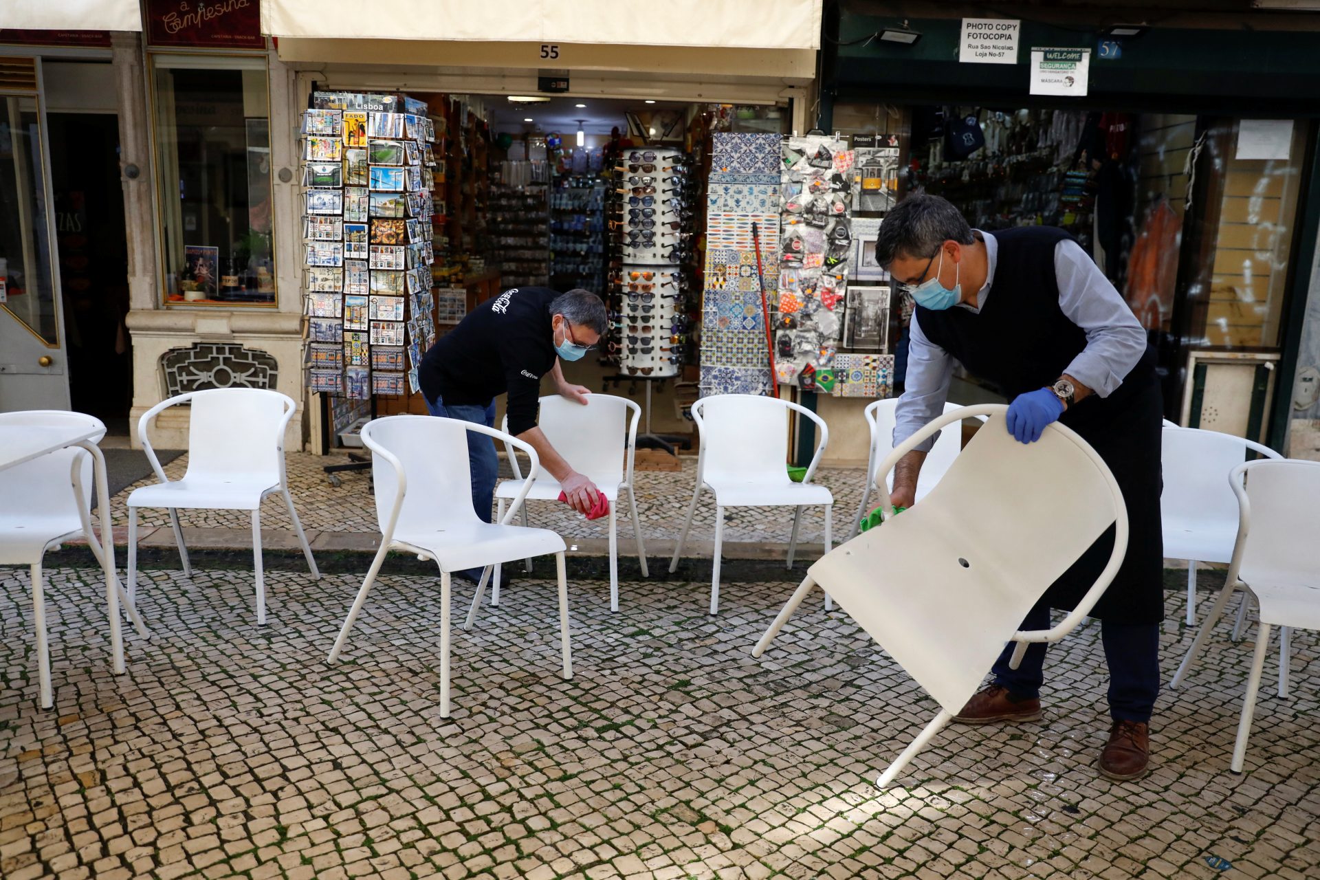 Workers clean chairs to open a restaurant terrace on the first day of the reopening after a country lockdown, amid the coronavirus disease (COVID-19) pandemic, in Lisbon, Portugal, April 5, 2021. REUTERS/Pedro Nunes