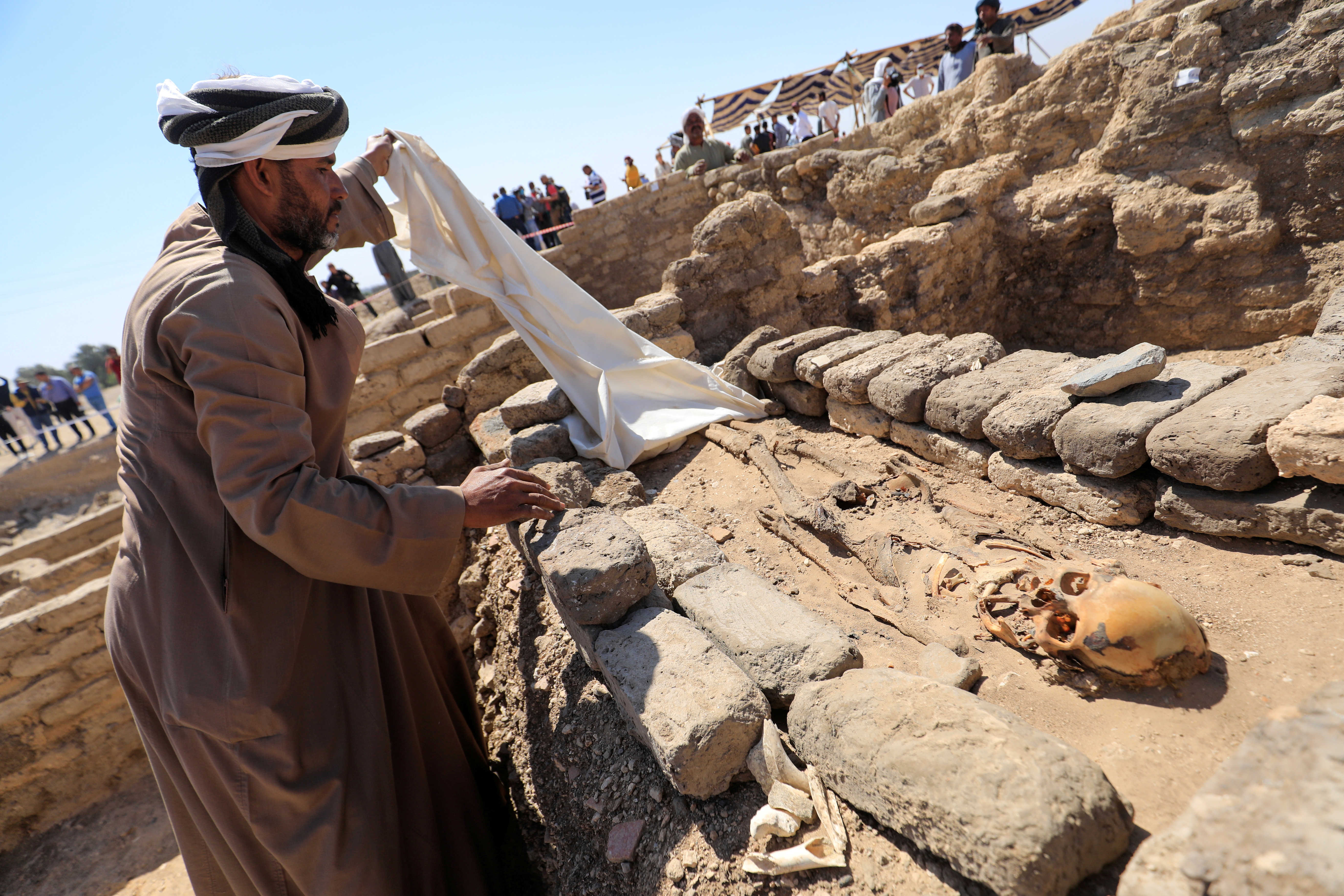 A man looks at skeletal human remains at the site of the 'Lost Golden City', which was recently discovered by archaeologists, in the West Bank of Luxor, Upper Egypt, April 10, 2021. REUTERS/Amr Abdallah Dalsh     TPX IMAGES OF THE DAY