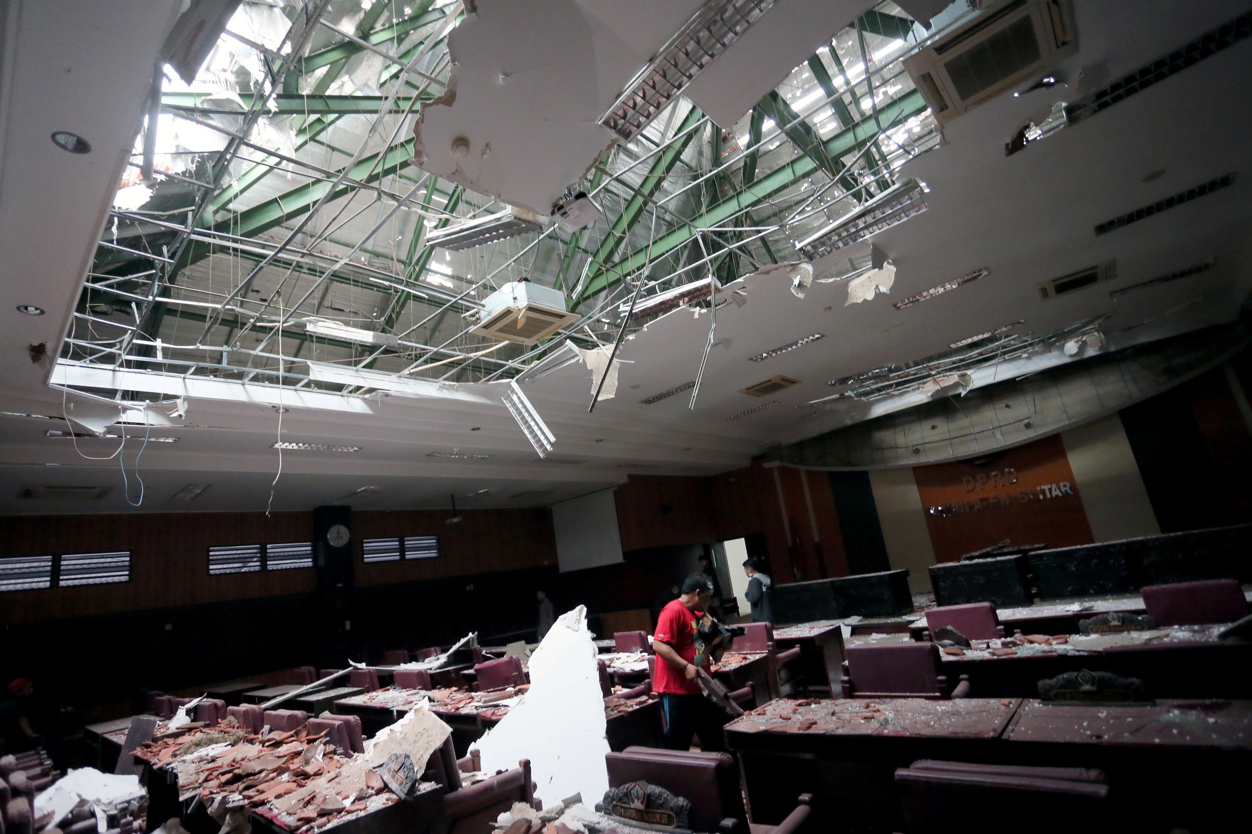 A man cleans up a damaged courtroom affected by an earthquake of magnitude 5.9 struck in the ocean 91 km (57 miles) south-southeast of Blitar