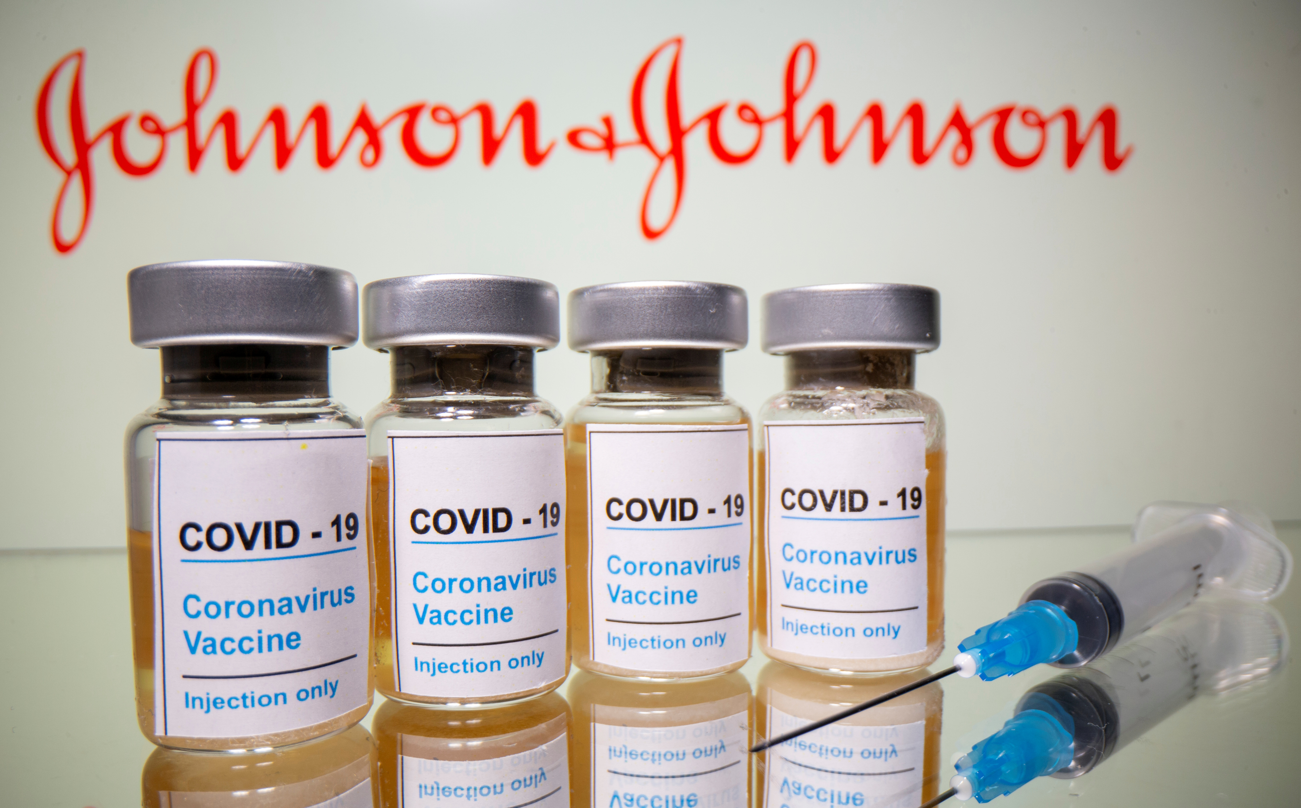 FILE PHOTO: Vials and medical syringe are seen in front of J&amp;J logo in this illustration