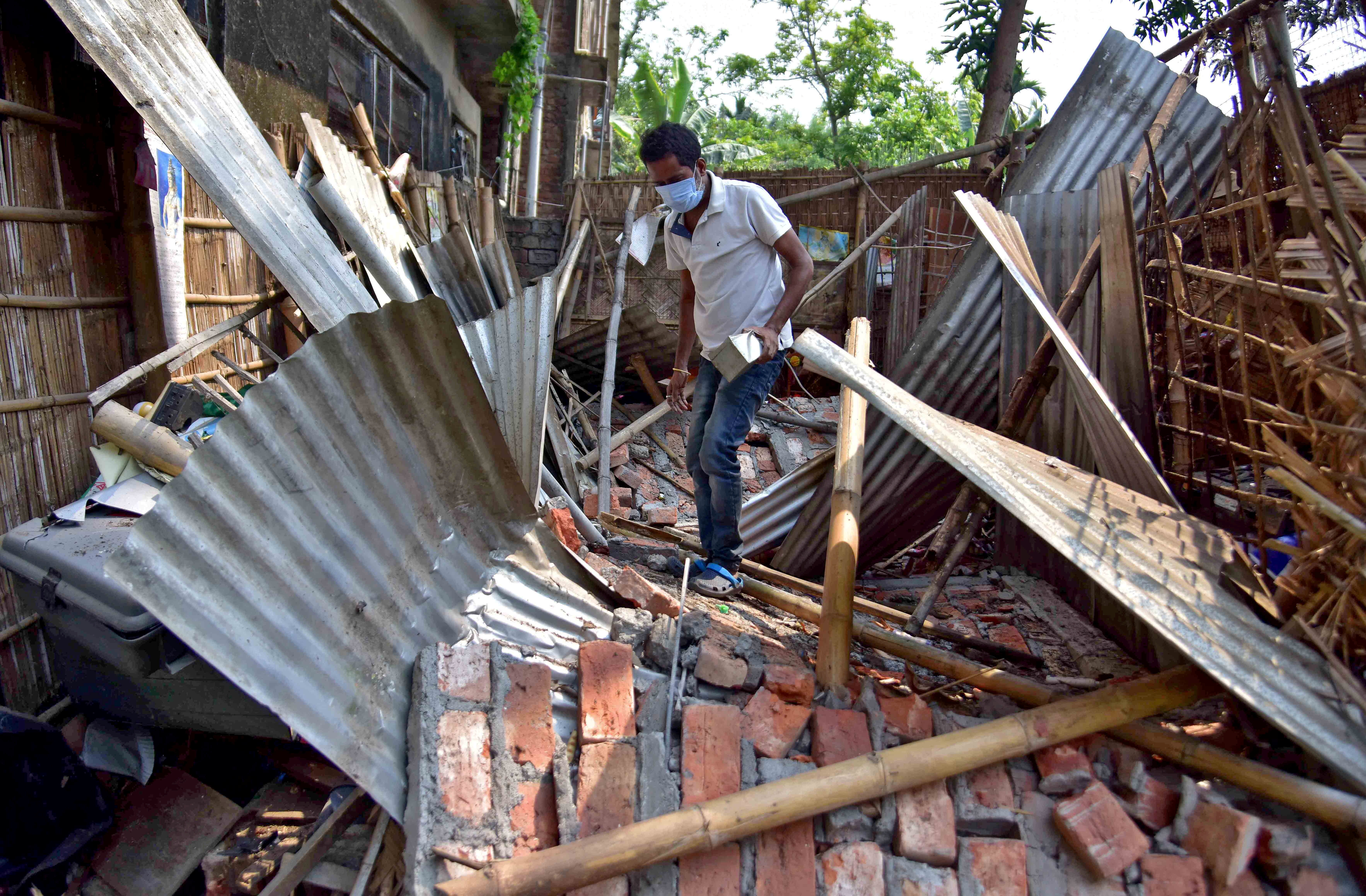 A man searches for his belongings amidst the debris after a boundary wall of his house collapsed following an earthquake in Nagaon district in the northeastern state of Assam, India, April 28, 2021. REUTERS/Anuwar Hazarika     TPX IMAGES OF THE DAY