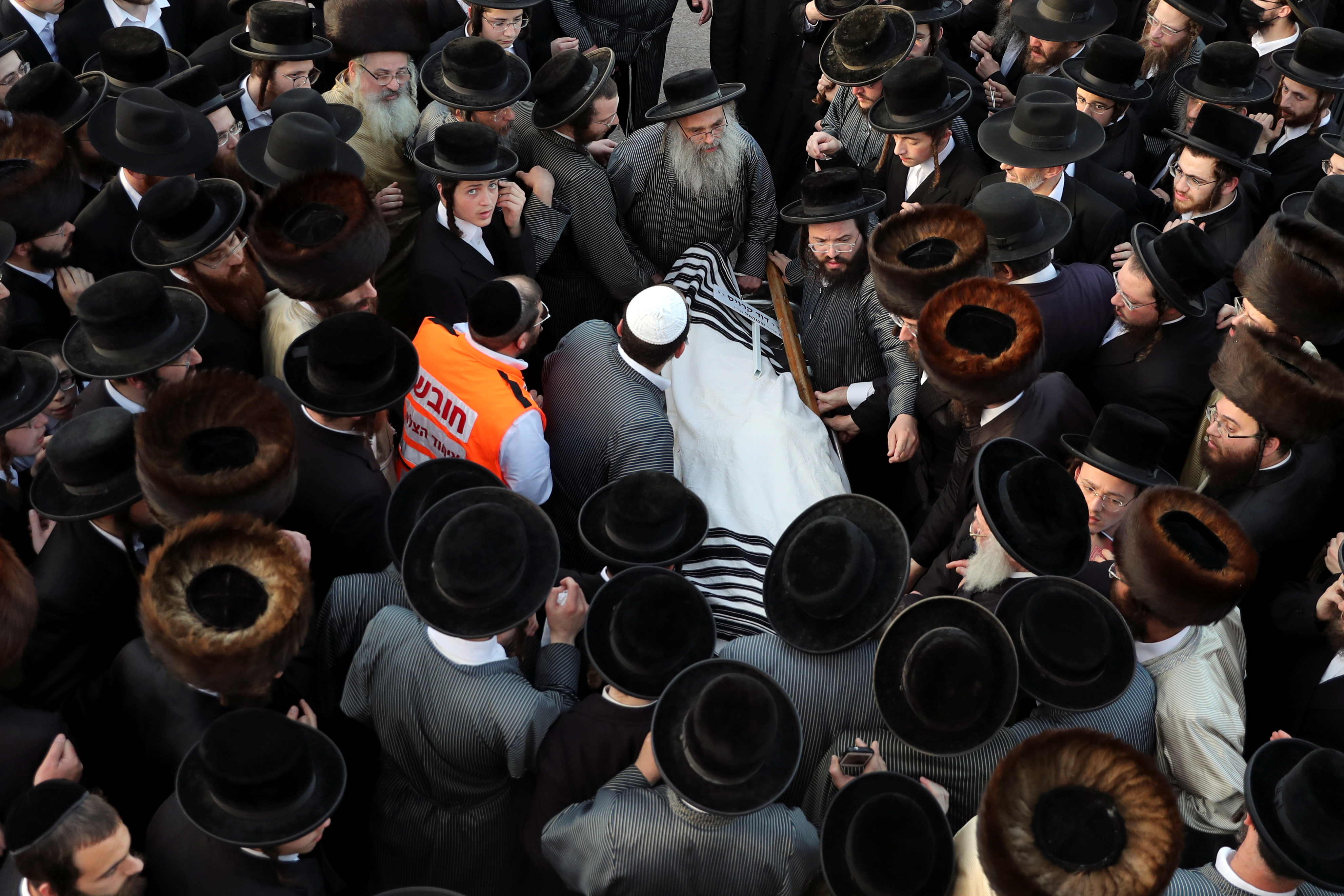 Ultra-Orthodox Jewish men mourn over the body of David Kroiess who died during Lag B'Omer commemorations on Mount Meron, during his funeral in Jerusalem April 30, 2021. REUTERS/Ronen Zvulun
