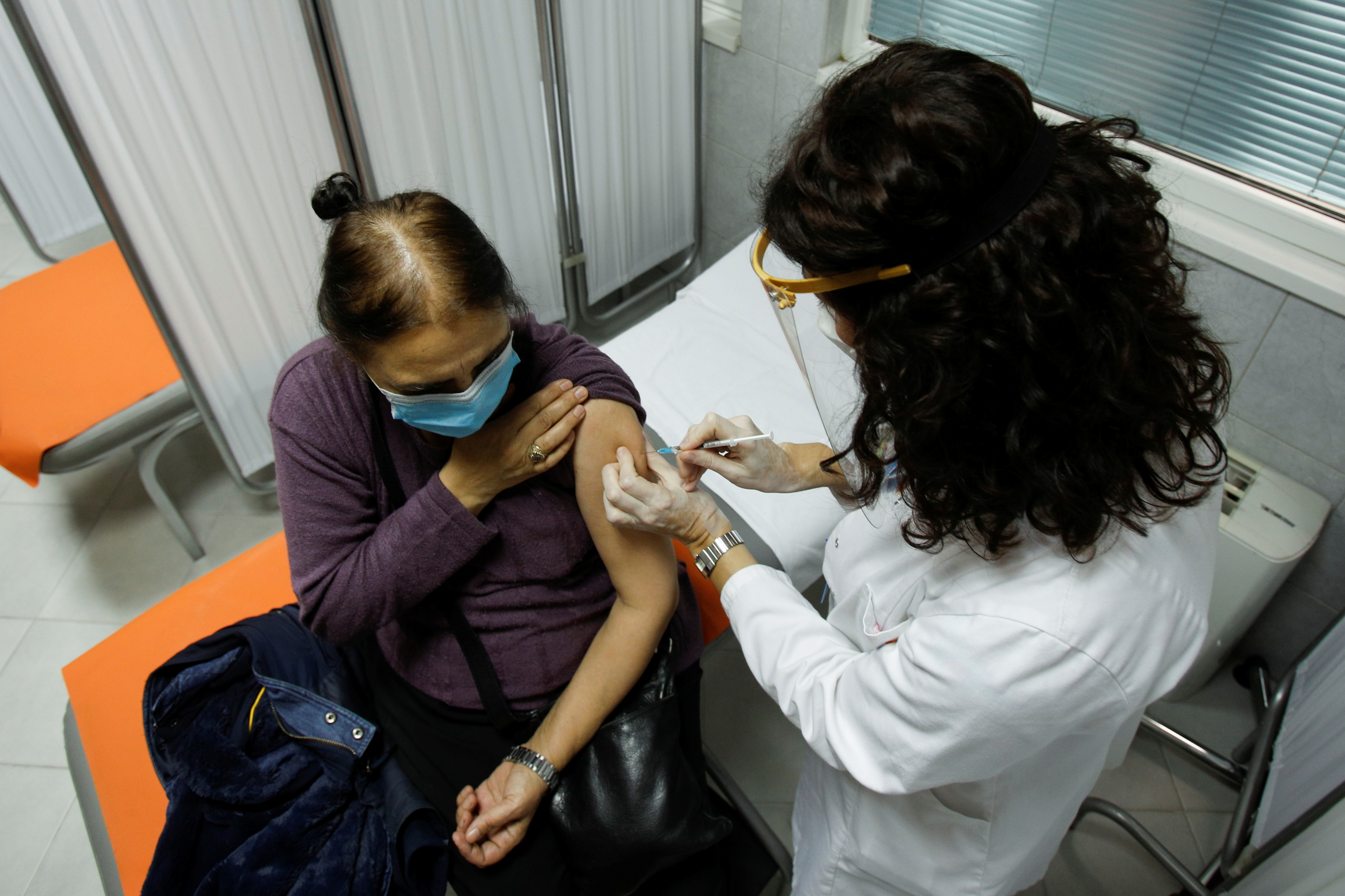 A healthcare worker administers a dose of the Sputnik V coronavirus disease (COVID-19) vaccine to her colleague in Podgorica, Montenegro, February 22, 2021. REUTERS/Stevo Vasiljevic
