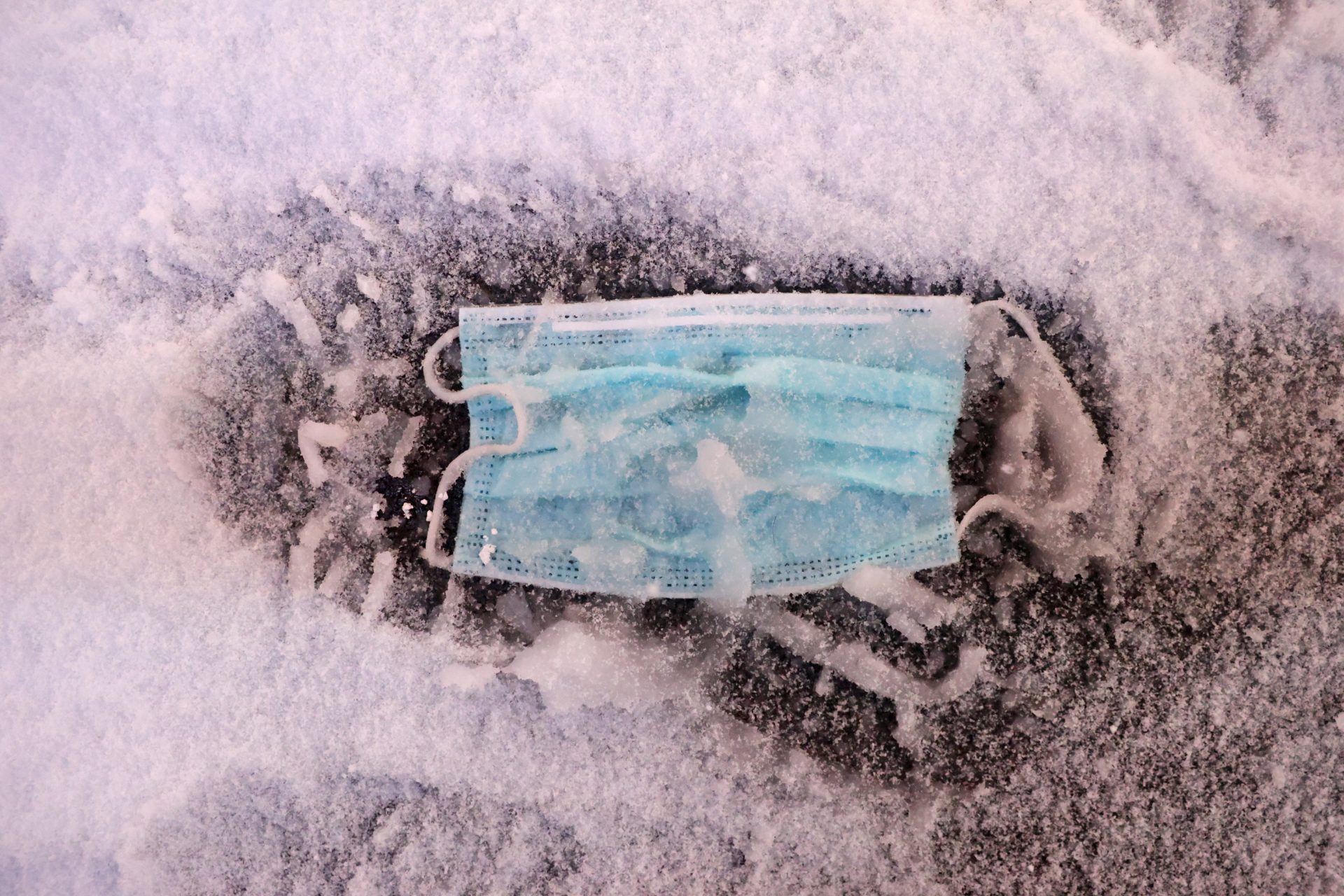 A face mask is seen on the ground as snow begins to fall in Times Square during a Nor'easter, during the coronavirus disease (COVID-19) pandemic in the Manhattan borough of New York City, New York, U.S., December 16, 2020. REUTERS/Jeenah Moon