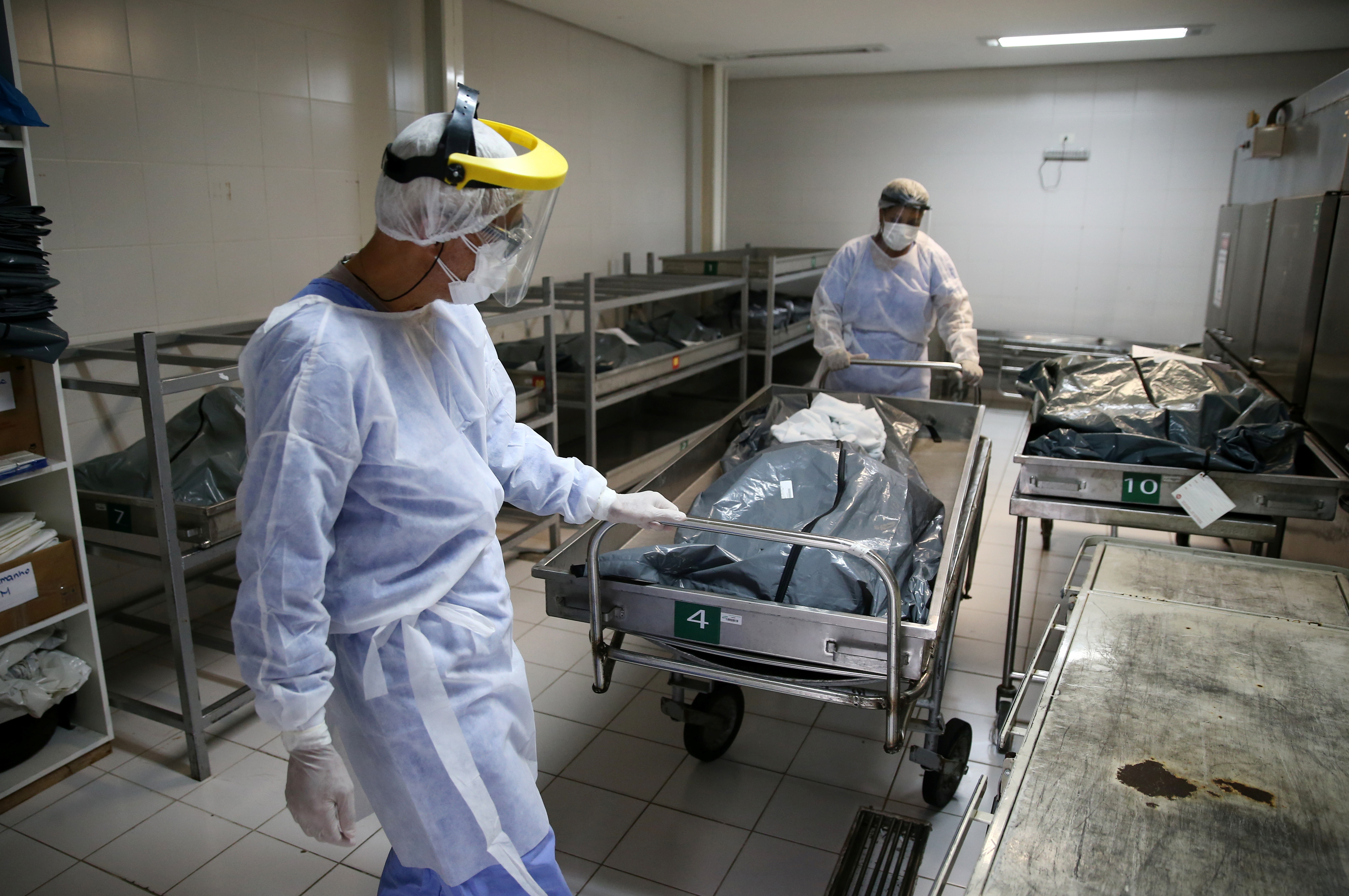 Medical workers in personal protective equipment (PPE) transfer the body of a COVID-19 victim at Nossa Senhora da Conceicao Hospital, amid the coronavirus disease (COVID-19) outbreak, in Porto Alegre, Brazil March 3, 2021. REUTERS/Diego Vara