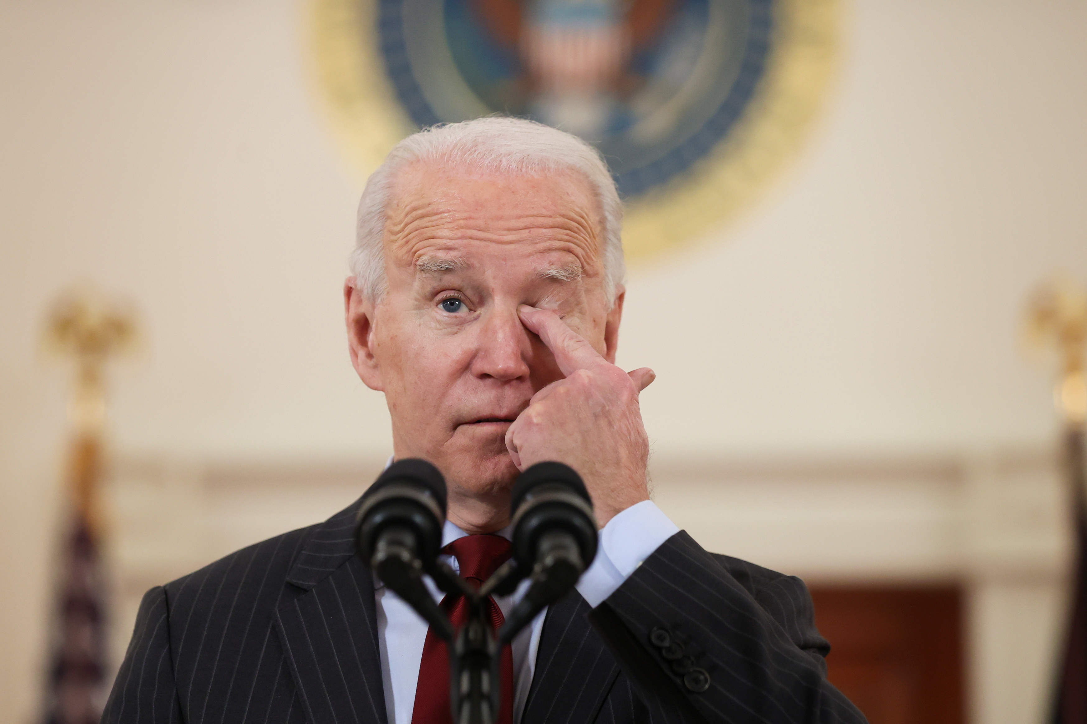 U.S. President Joe Biden touches his face as he delivers remarks in honor of the 500,000 U.S. deaths from the coronavirus disease (COVID-19), in the Cross Hall at the White House in Washington, U.S., February 22, 2021. REUTERS/Jonathan Ernst