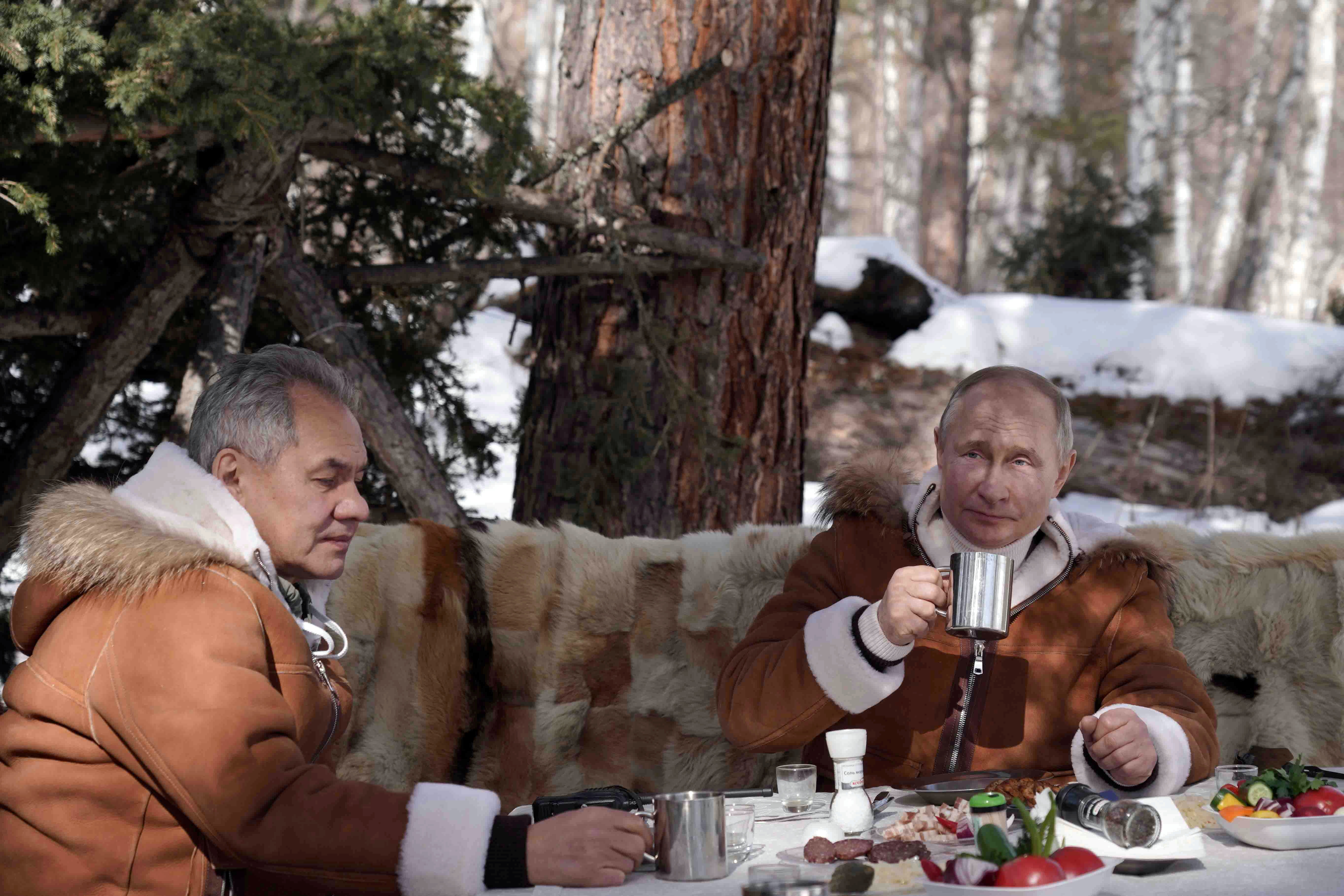 Russian President Vladimir Putin and Defence Minister Sergei Shoigu sit at a table during a holiday in the Siberian taiga, Russia March 21, 2021.  Sputnik/Alexei Druzhinin/Kremlin via REUTERS ATTENTION EDITORS - THIS IMAGE WAS PROVIDED BY A THIRD PARTY.