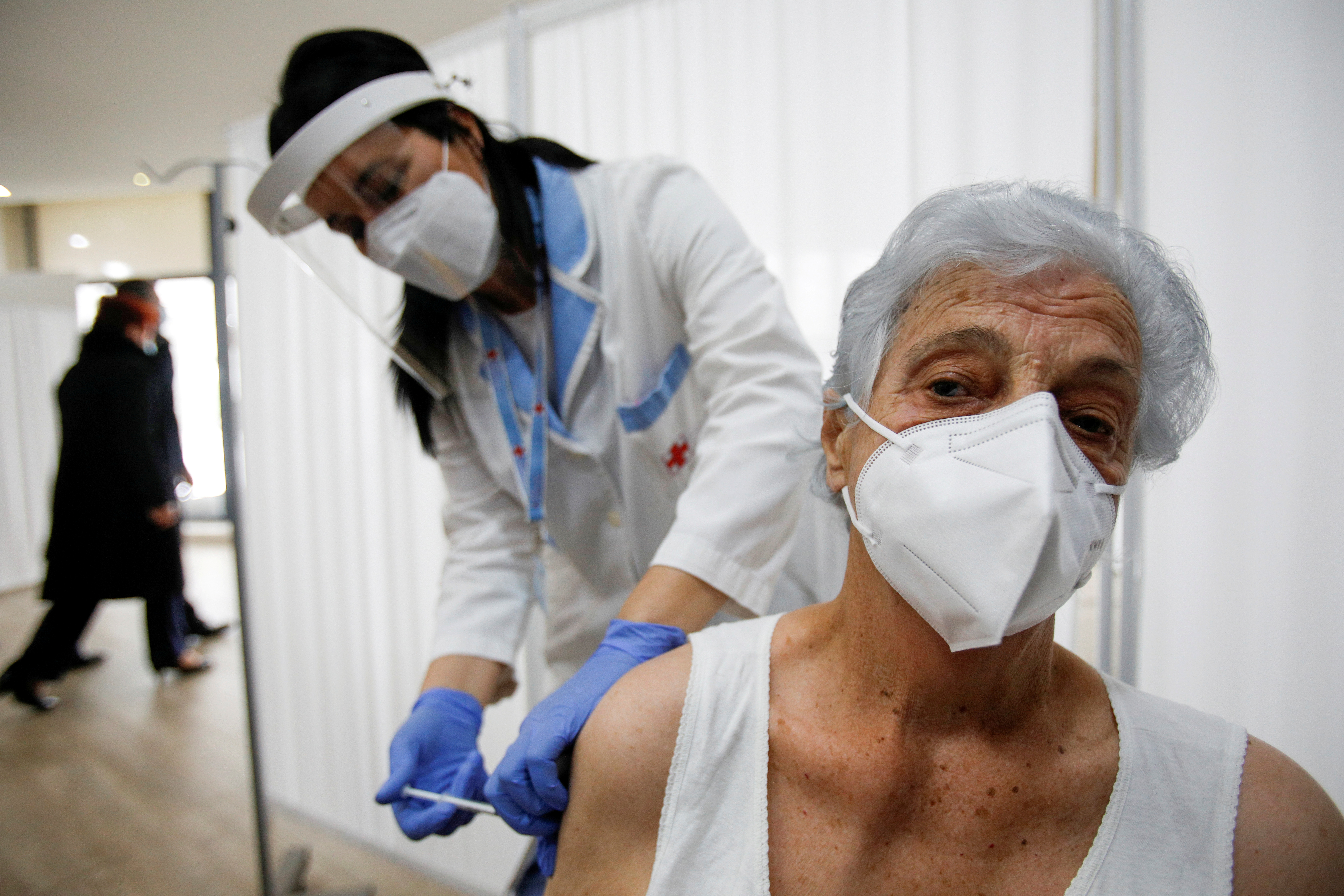 FILE PHOTO: A woman receives a coronavirus disease (COVID-19) vaccine during the start of the mass inoculation programme in Podgorica, Montenegro, March 8, 2021. REUTERS/Stevo Vasiljevic/File Photo