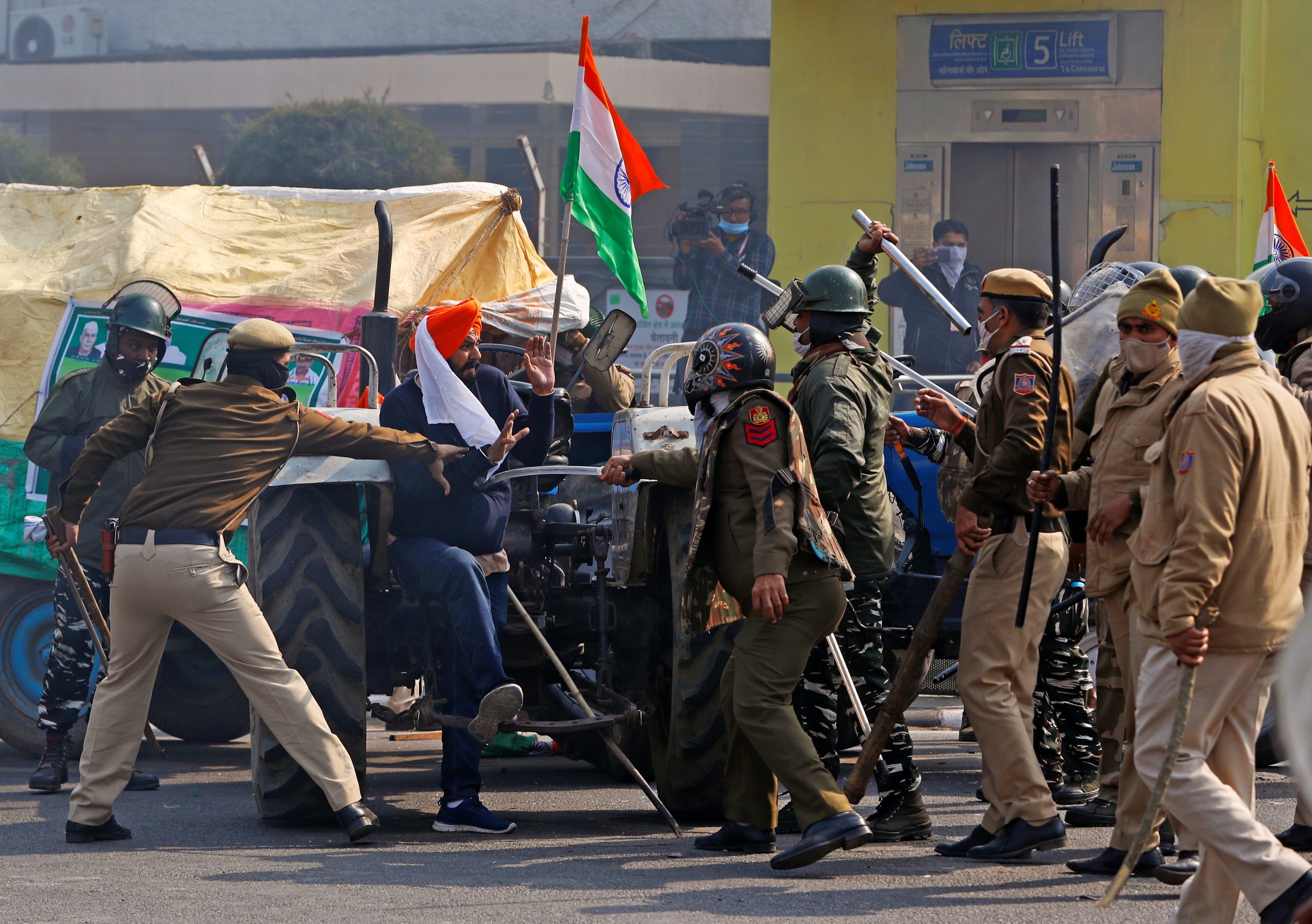 Police officers scuffle with a demonstrator during a protest against farm laws introduced by the government, in New Delhi, India, January 26, 2021. REUTERS/Adnan Abidi