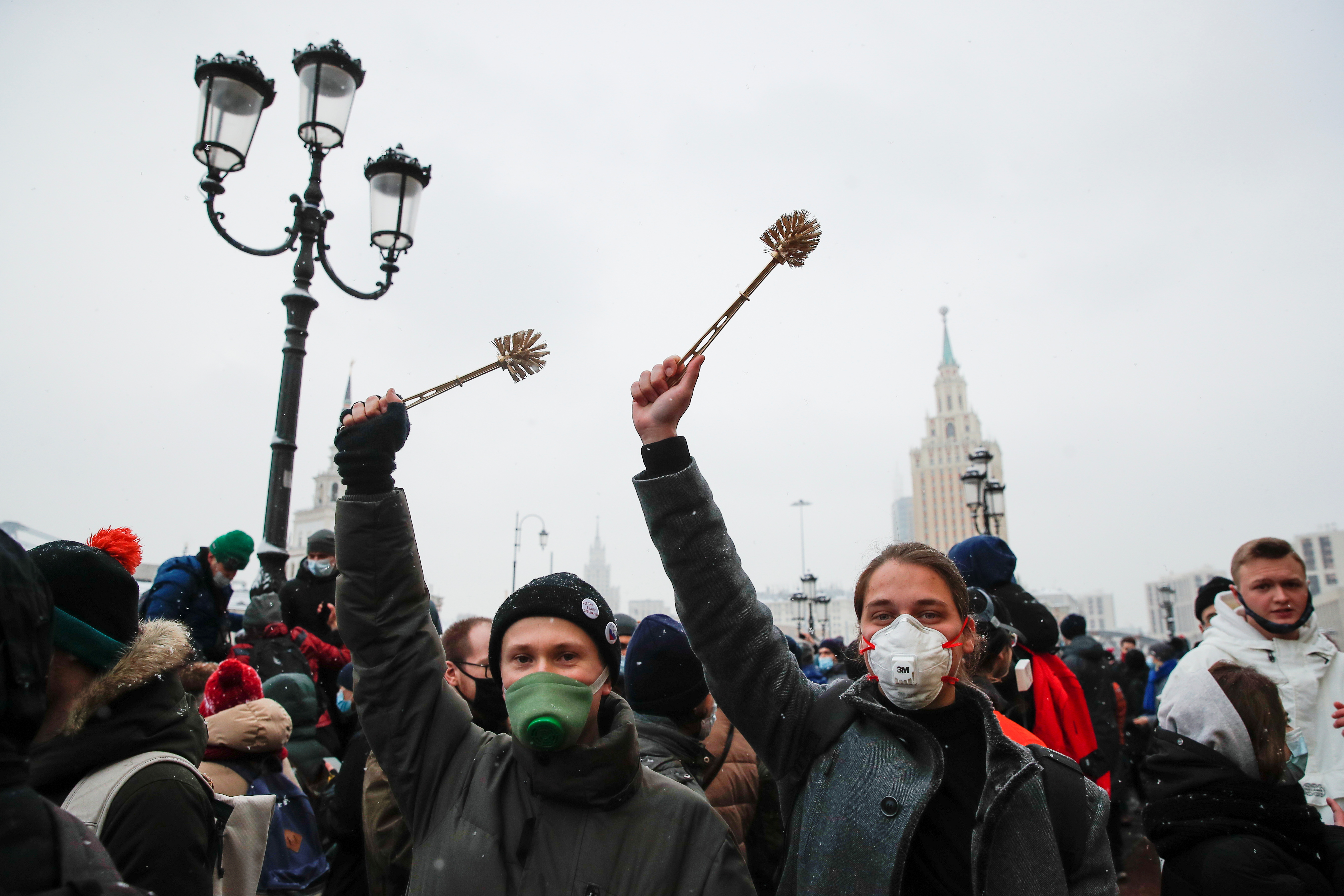 People hold up toilet brushes during a rally in support of jailed Russian opposition leader Alexei Navalny in Moscow, Russia January 31, 2021. REUTERS/Maxim Shemetov