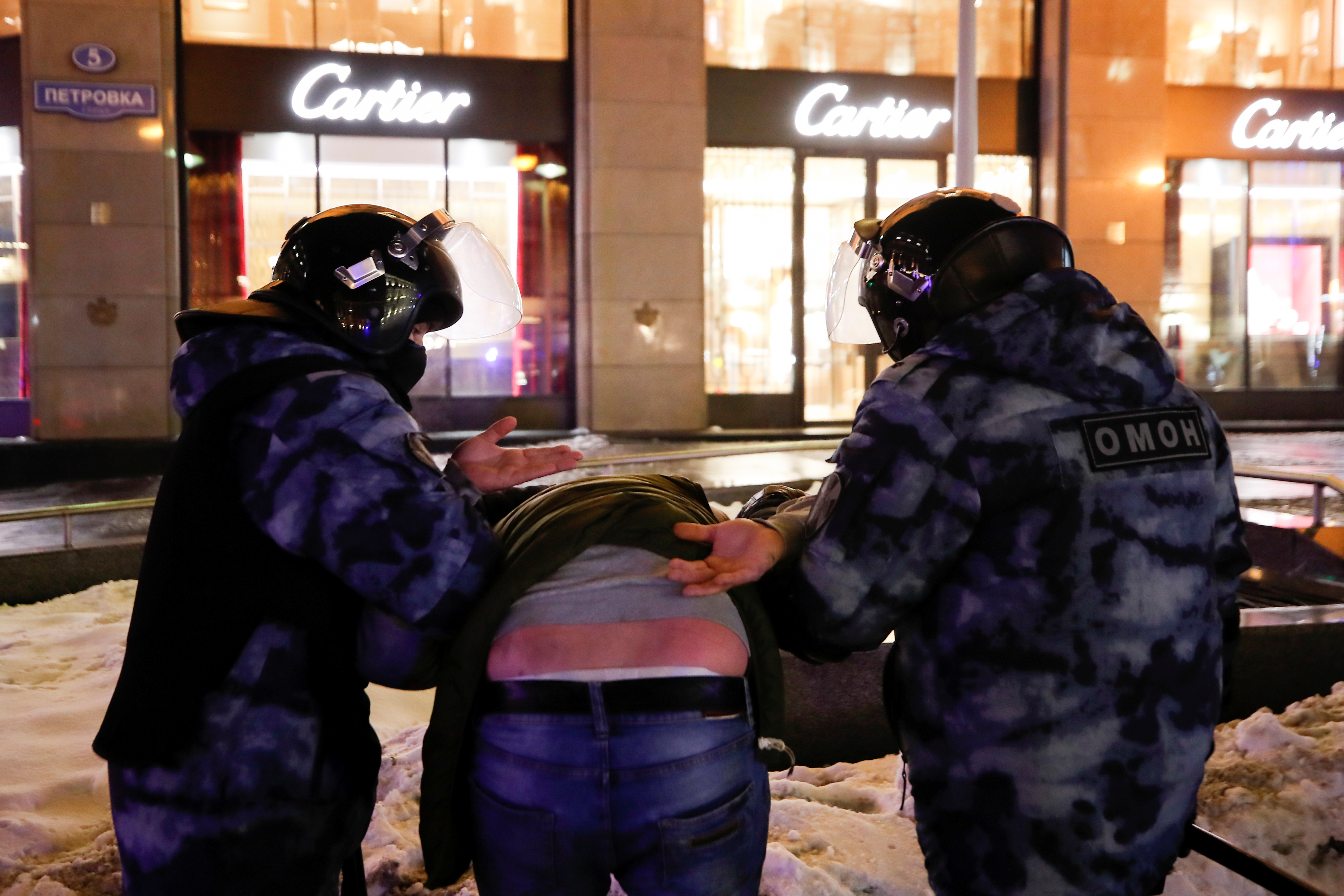 Law enforcement officers detain a person during a demonstration after Russian opposition leader Alexei Navalny was sentenced to three and a half years in jail, in Moscow, Russia February 3, 2021. REUTERS/Maxim Shemetov
