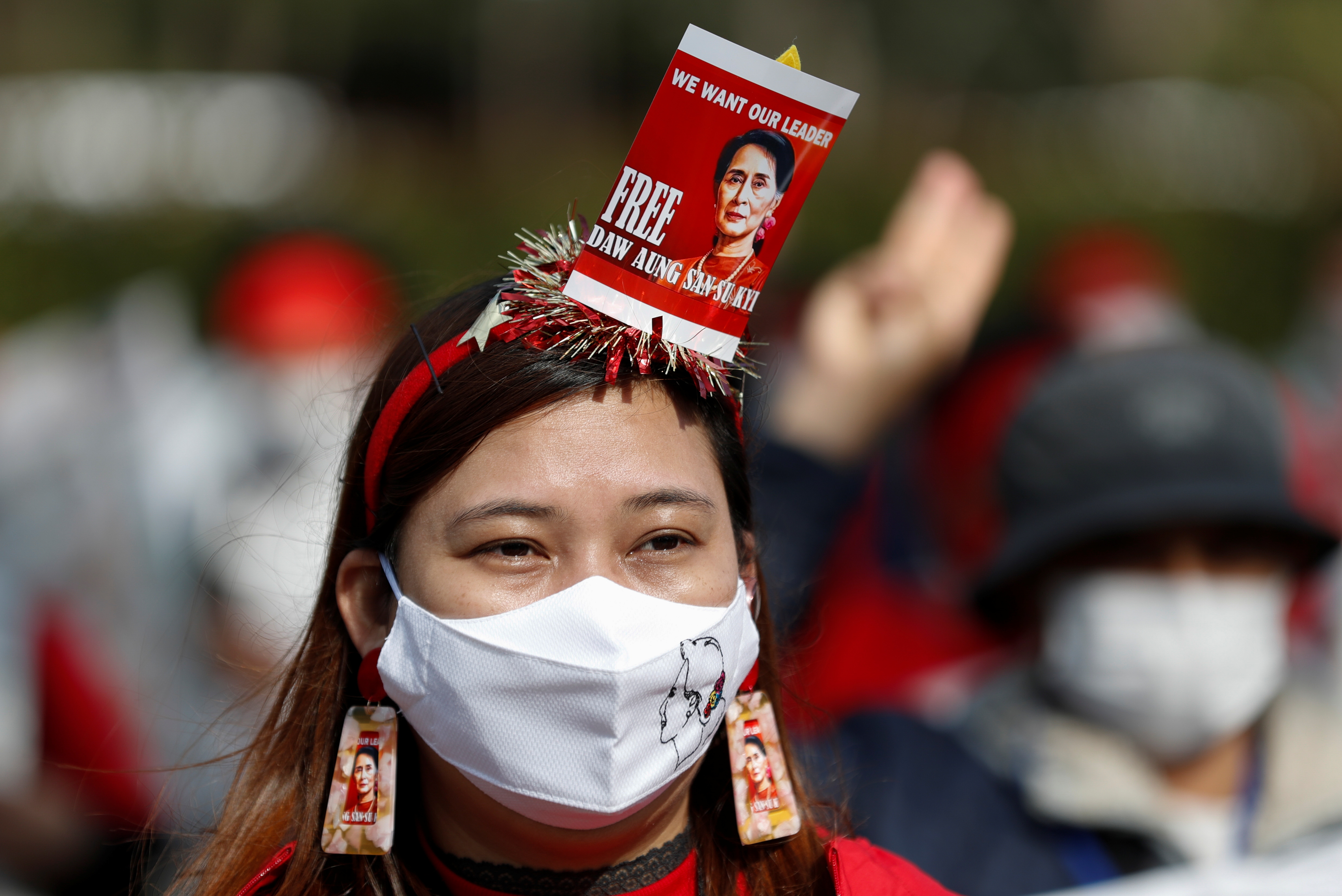 A demonstrator wears a face mask and earrings with images depicting Aung San Suu Kyi during a protest against the military coup in Myanmar, in central Tokyo, Japan February 14, 2021. REUTERS/Kim Kyung-Hoon