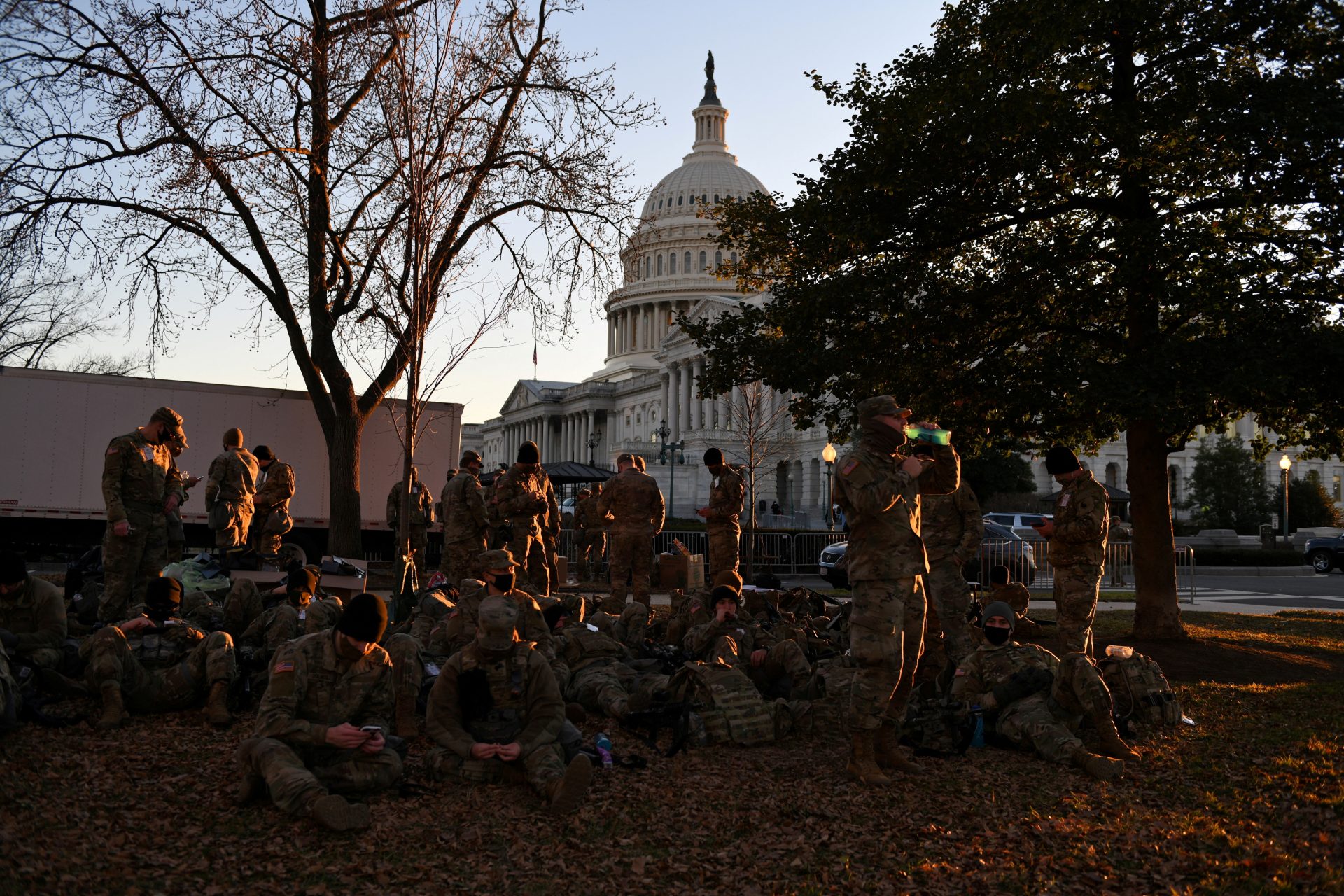 National Guard troops rest on a yard in front of the U.S. Capitol ahead of U.S. President-elect Joe Biden's inauguration, in Washington, U.S., January 19, 2021. REUTERS/Brandon Bell   REFILE - CORRECTING BYLINE