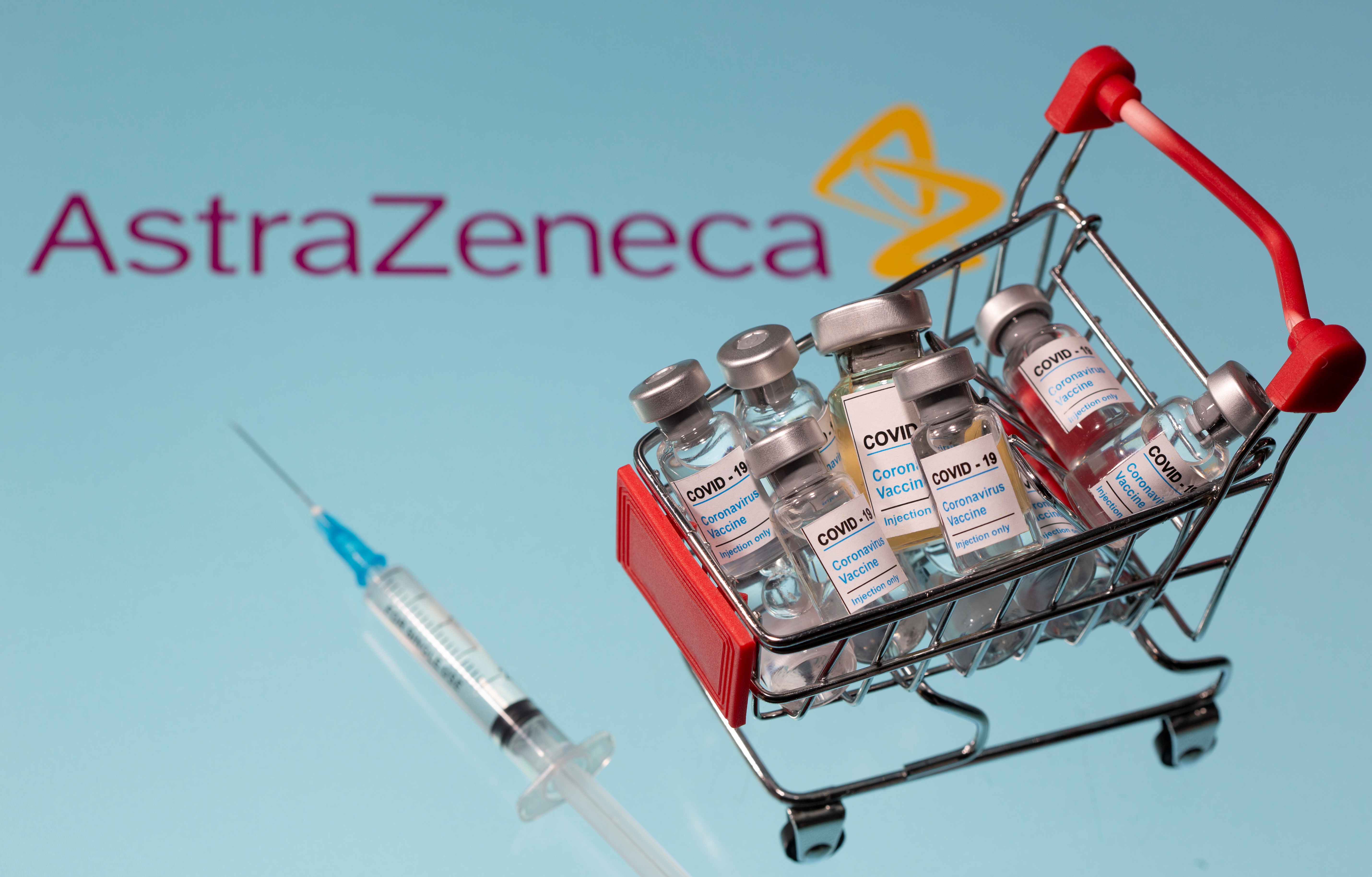 A small shopping basket filled with vials labeled "COVID-19 - Coronavirus Vaccine" and a medical sryinge are placed on a AstraZeneca logo in this illustration taken November 29, 2020. Picture taken November 29, 2020. REUTERS/Dado Ruvic/Ilustration
