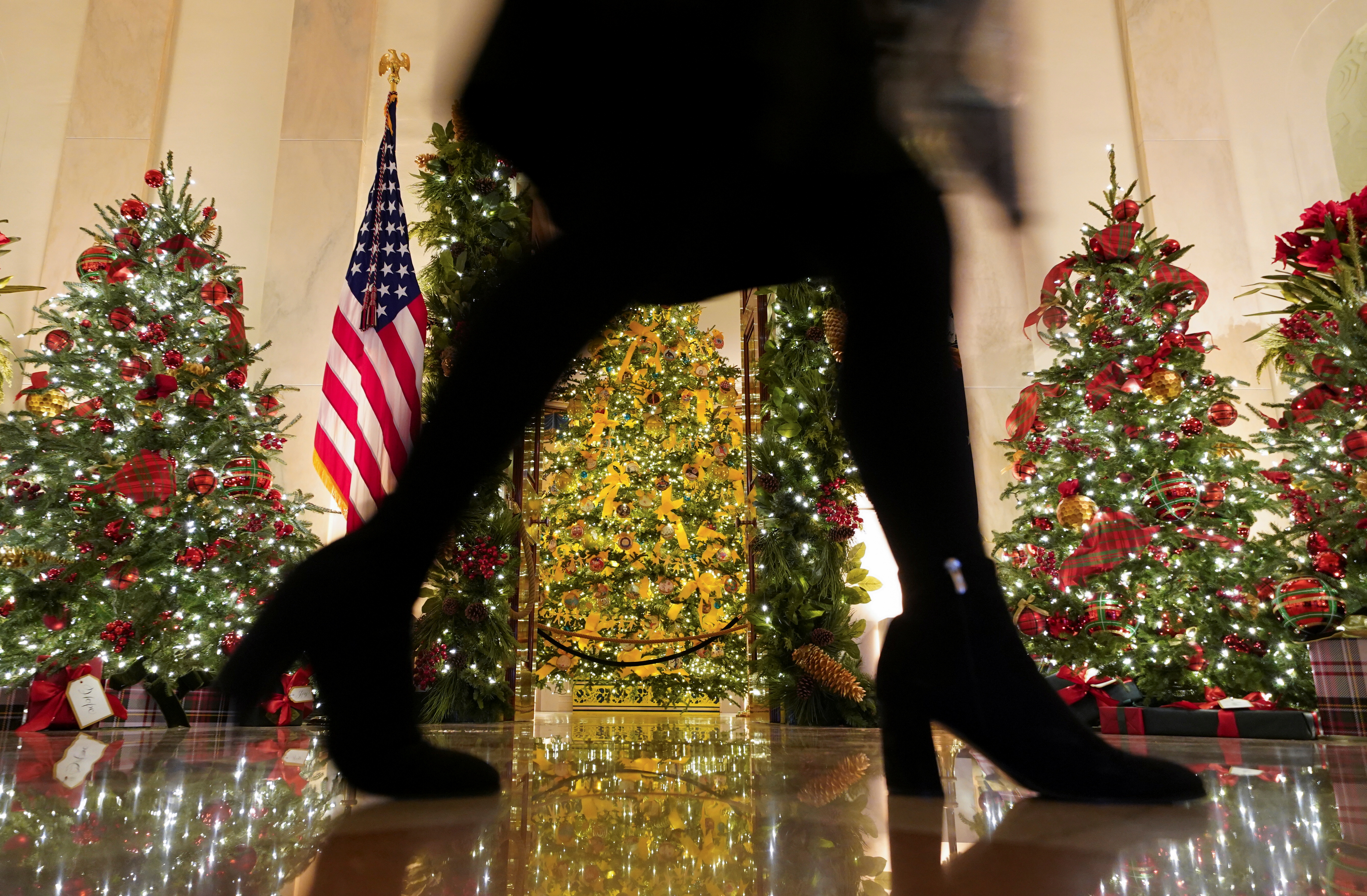 A woman walks through the Cross Hall of the White House during a holiday decoration press preview in Washington, U.S., November 30, 2020.  REUTERS/Kevin Lamarque