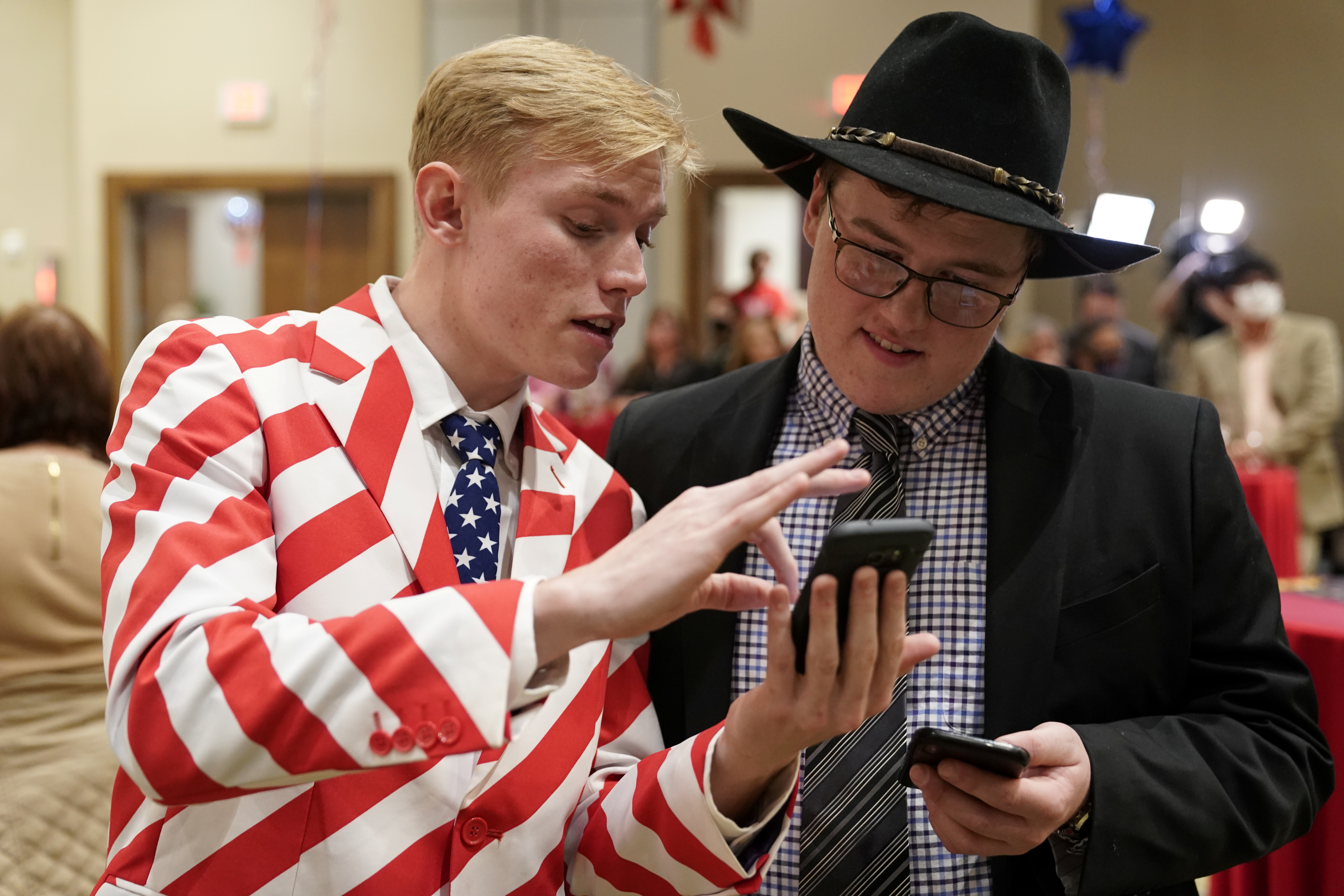 Supporters of U.S. President Donald Trump, Caleb McQuay (L) and Gideon Bodley look at early election results at the Oklahoma GOP watch party in Edmond, Oklahoma U.S., November 3, 2020.  REUTERS/Nick Oxford