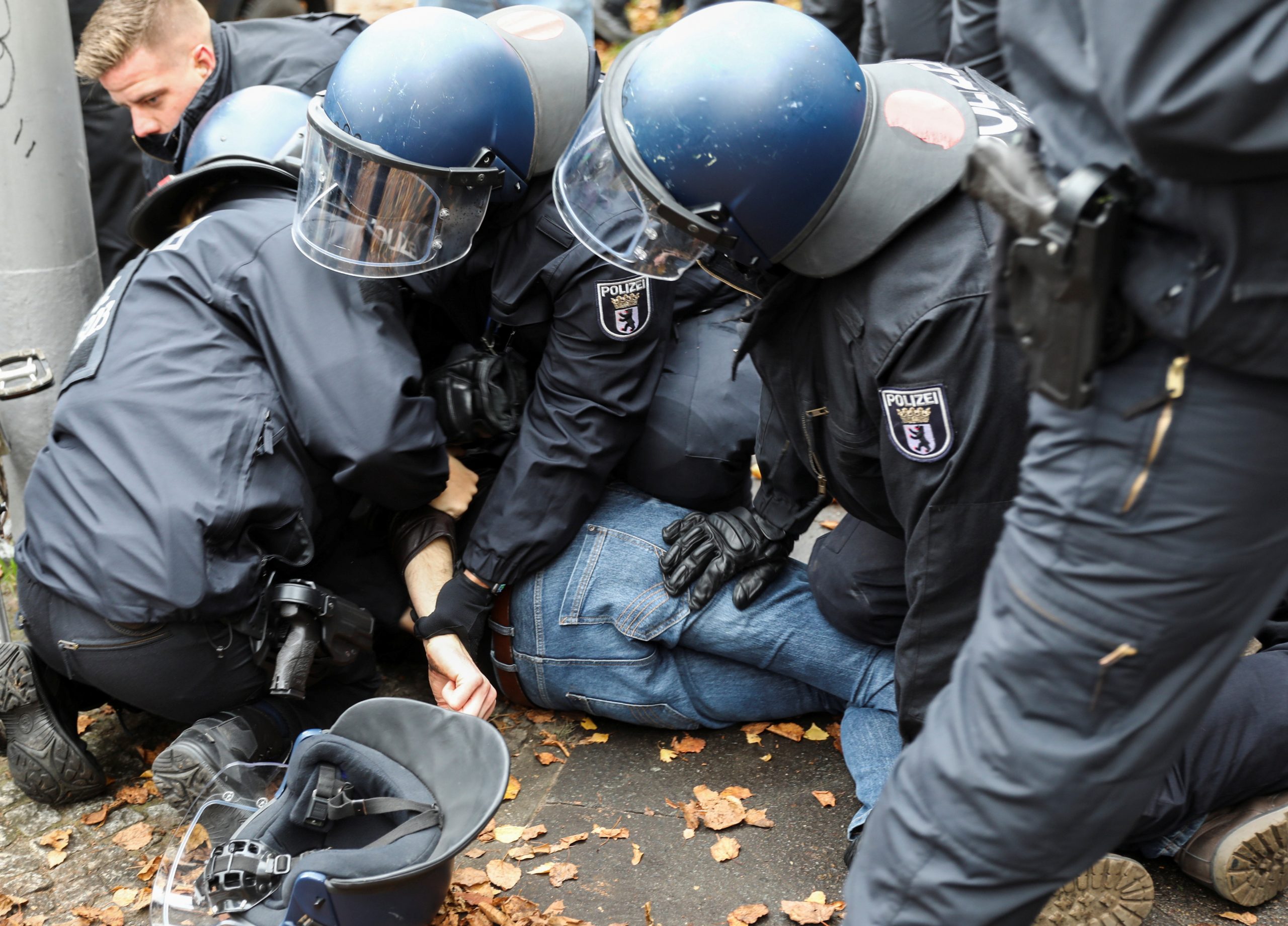 Police officers try to remove a counter-protester from a street during a demonstration against the government's coronavirus disease (COVID-19) restrictions in Berlin, Germany, November 22, 2020. REUTERS/Christian Mang