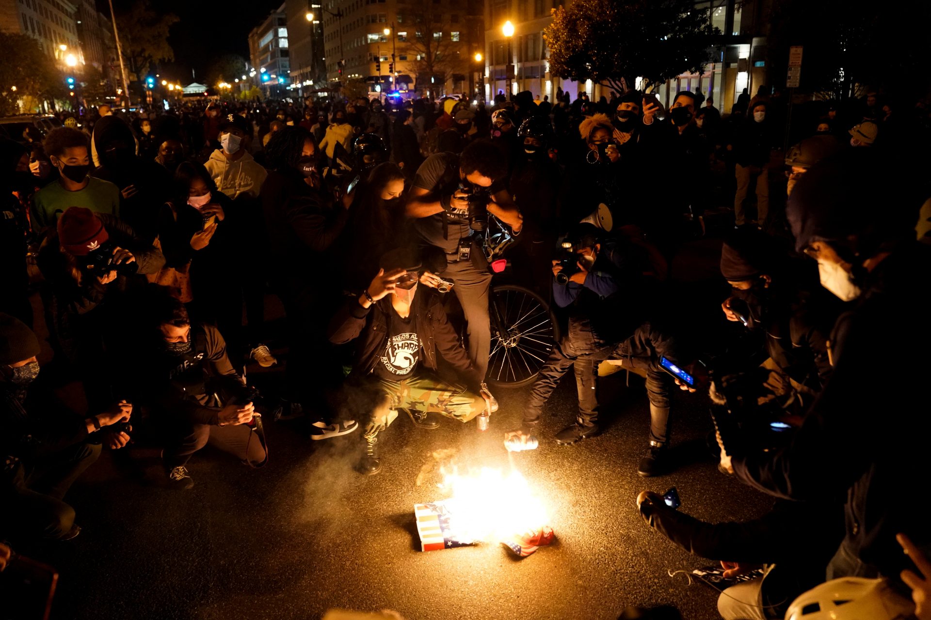 Protesters set fire to a Make America Great Again (MAGA) hat and a poster depicting U.S. President Donald Trump in Washington, U.S., November 14, 2020. REUTERS/Erin Scott