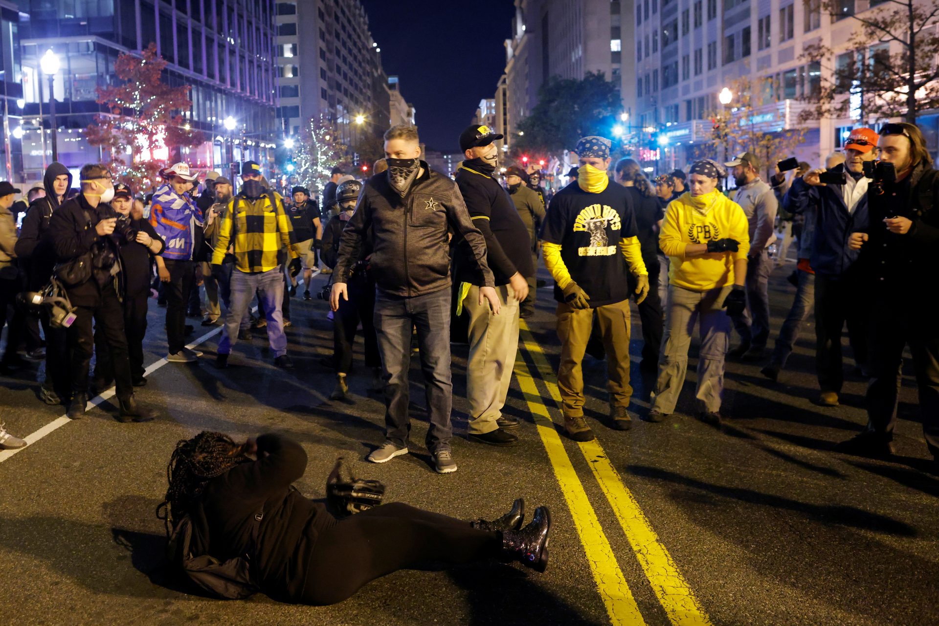 A woman lies on the ground surrounded by members of far-right militia Proud Boys during a scuffle following a protest against election results, in Washington, U.S. November 14, 2020. REUTERS/Carlos Barria