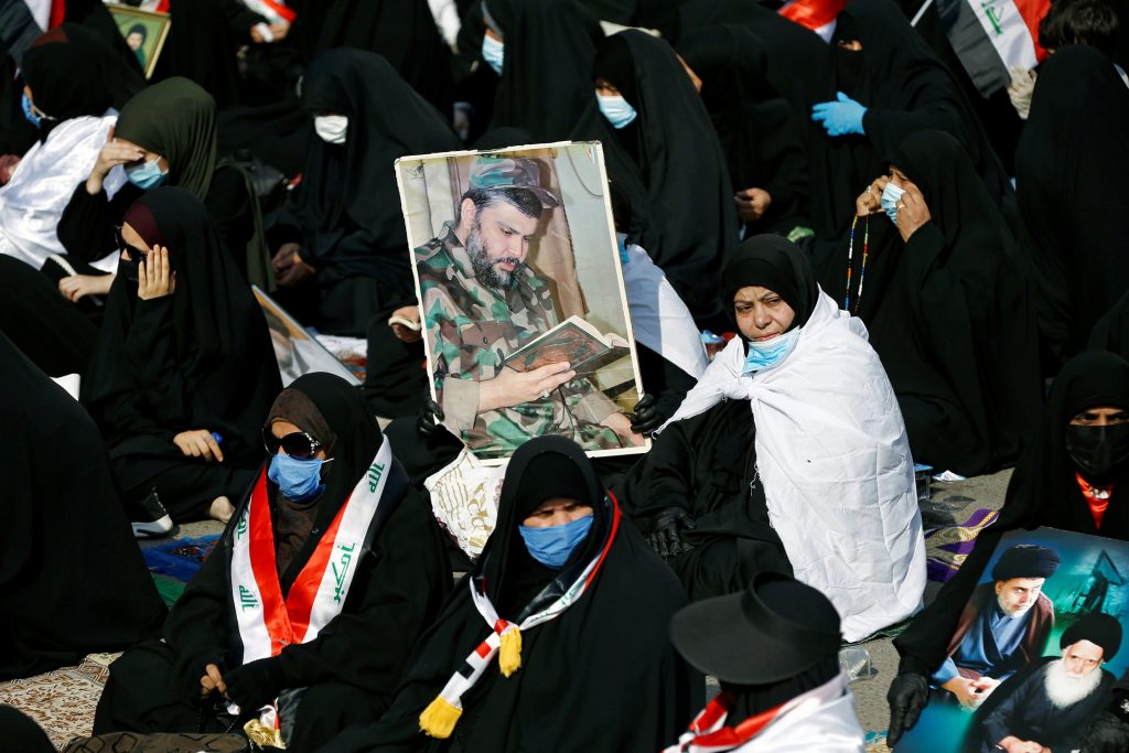 Supporters of Iraqi Shi'ite cleric Moqtada al-Sadr hold a picture of him during a rally in support of al-Sadr in Baghdad, Iraq November 27, 2020. REUTERS/Khalid al-Mousily
