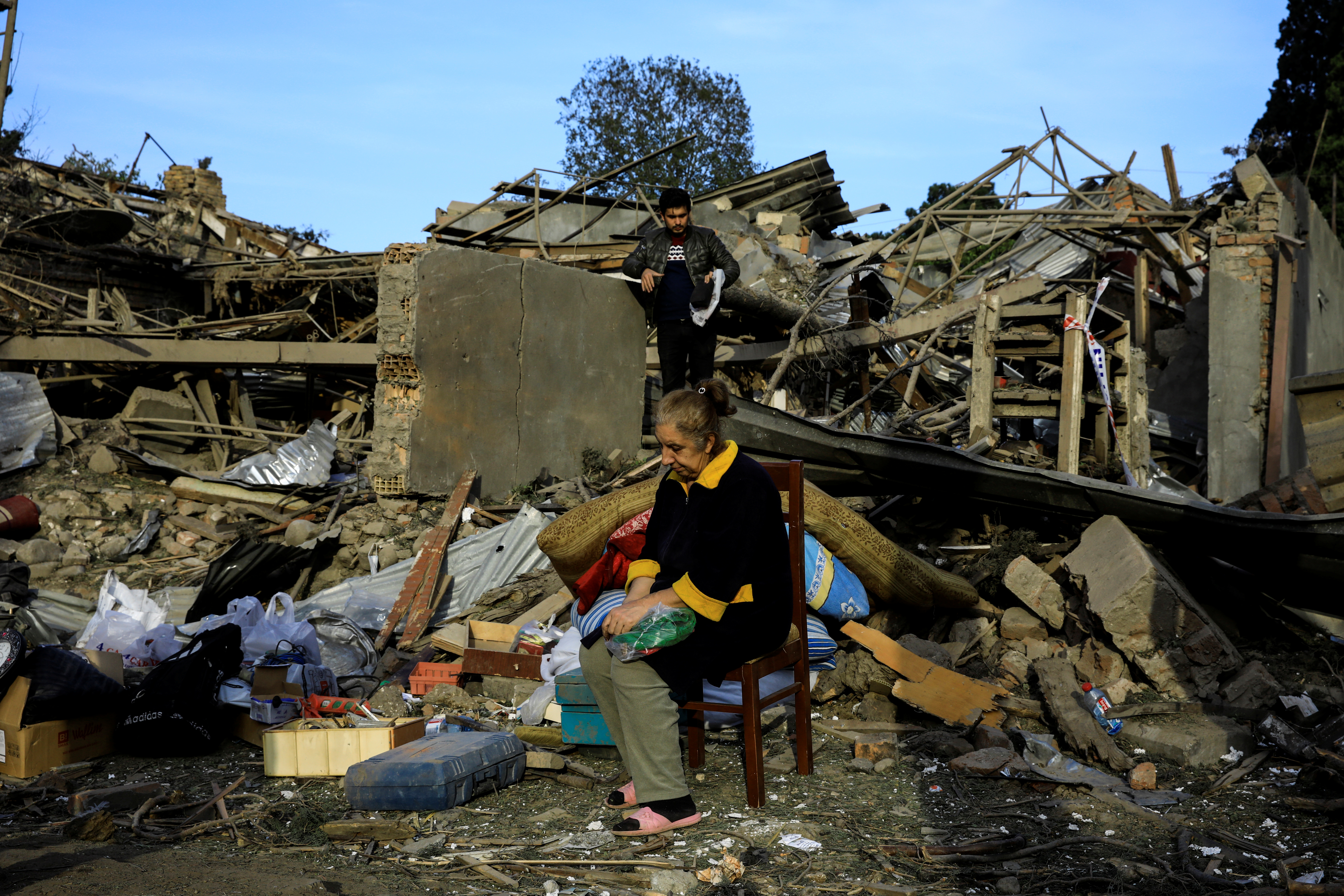 Jermenija, Azerbejdžan, Vesile Mehmedova sits in front of debris of her brother's home as her relatives search for belongings, at a blast site hit by a rocket during the fighting over the breakaway region of Nagorno-Karabakh in the city of Ganja