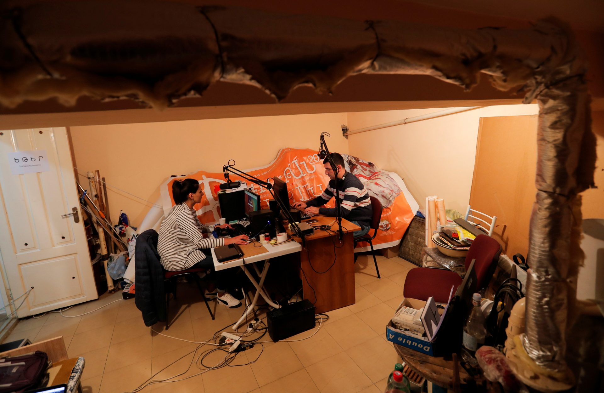 Radio journalists from a local public radio work at their studio located in a basement during the military conflict over the breakaway region of Nagorno-Karabakh, in Stepanakert October 12, 2020.  REUTERS/Stringer