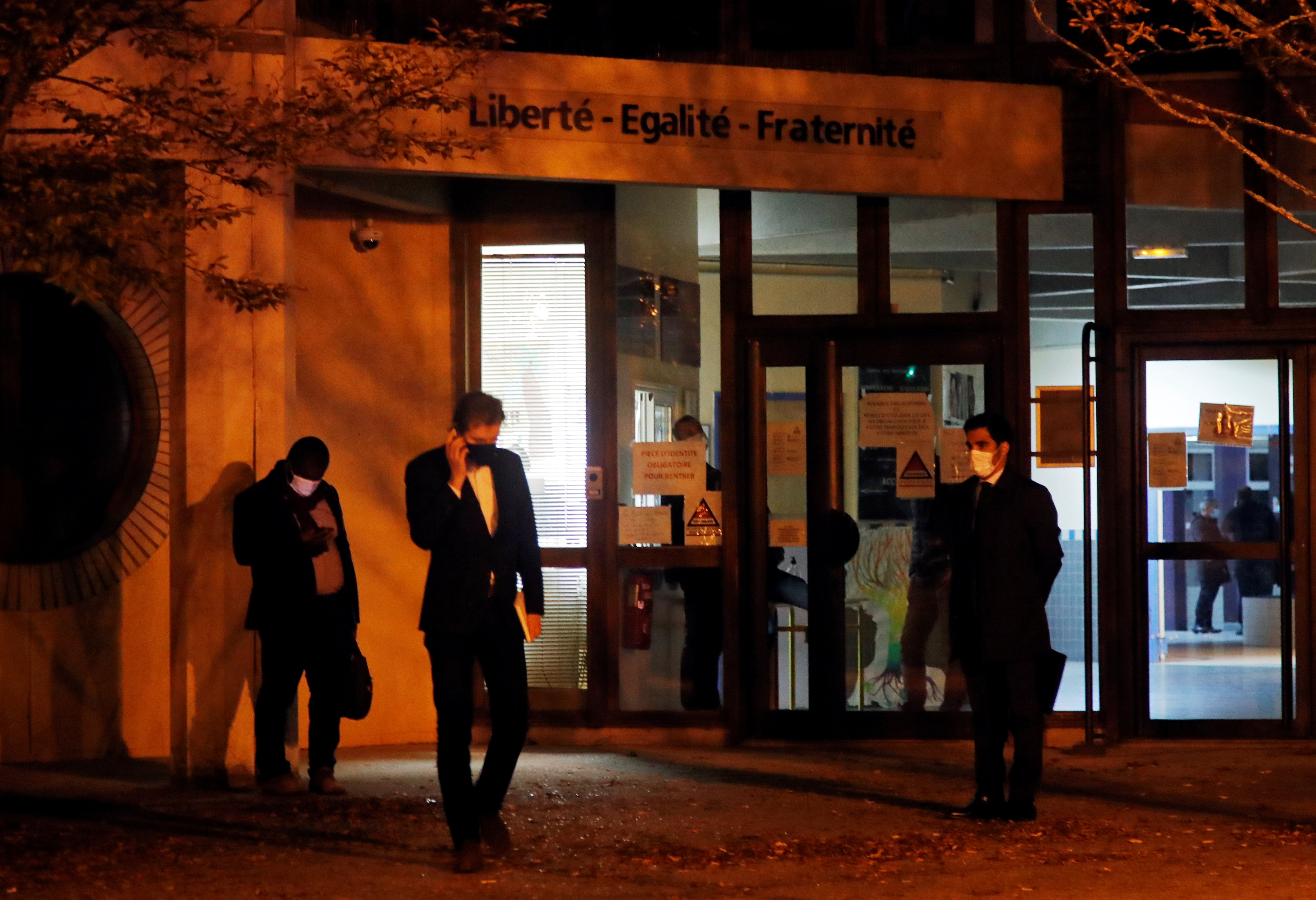 People are seen outside an entrance area near the scene of a stabbing attack in the Paris suburb of Conflans St Honorine, France, October 16, 2020. REUTERS/Charles Platiau