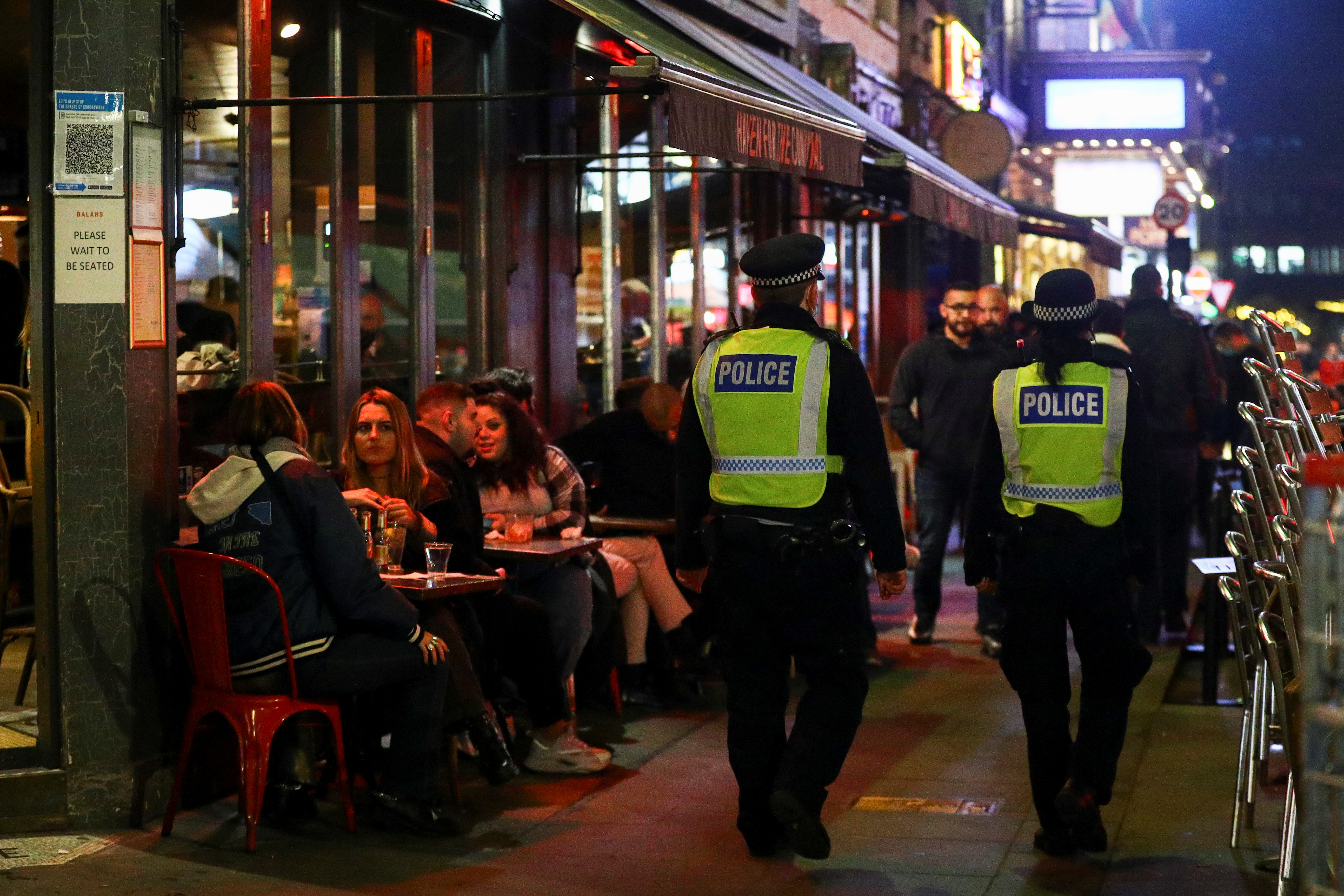 Police offices walk past bars in Soho, amid the outbreak of the coronavirus disease (COVID-19), in London, Britain October 16, 2020. REUTERS/Hannah McKay