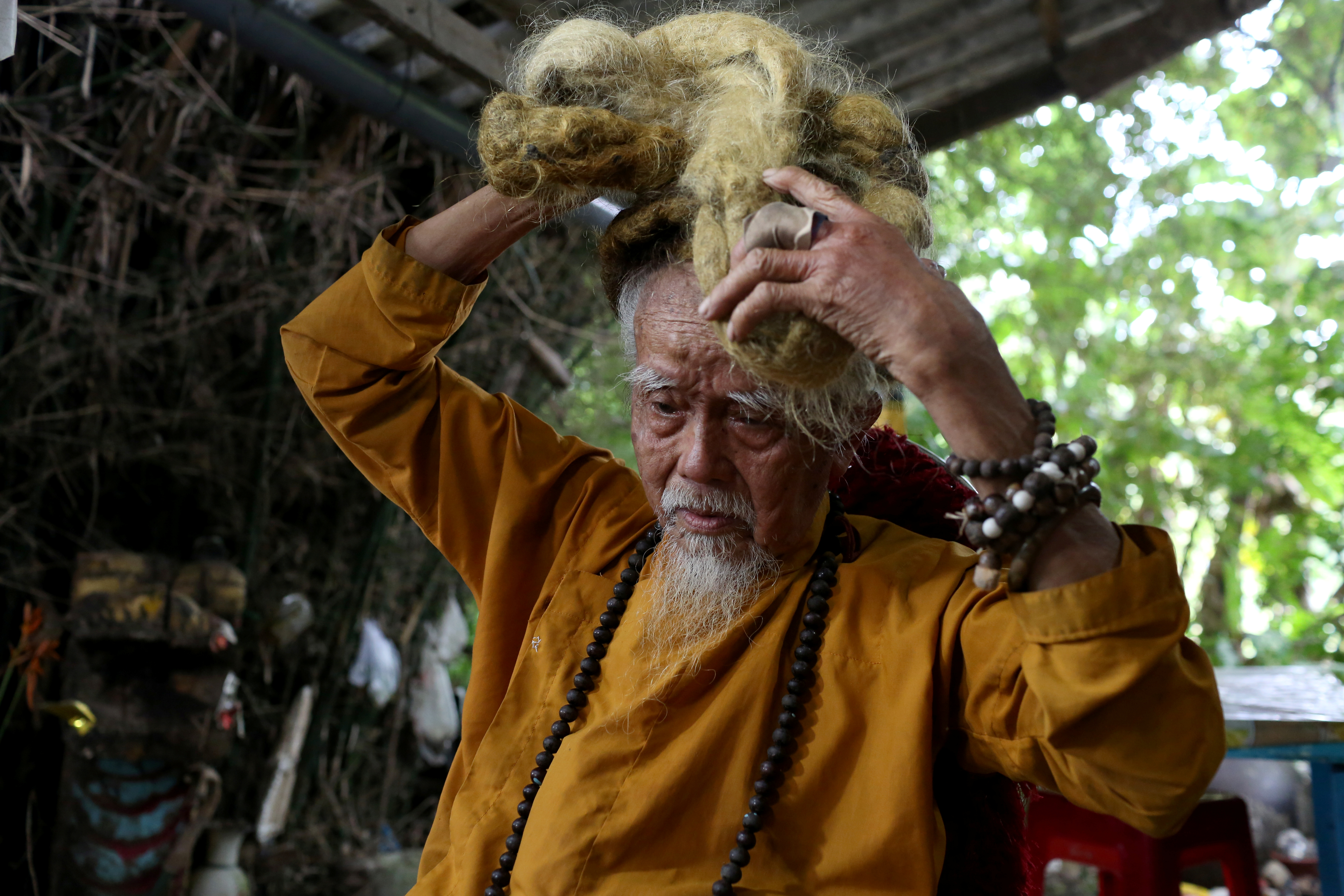 Nguyen Van Chien, 92, sits for a portrait to show his 5-meter long hair which, according to him, has not been cut for nearly 70 years, at his home in Tien Giang province, Vietnam , August 21, 2020. Picture taken August 21, 2020. REUTERS/Yen Doung