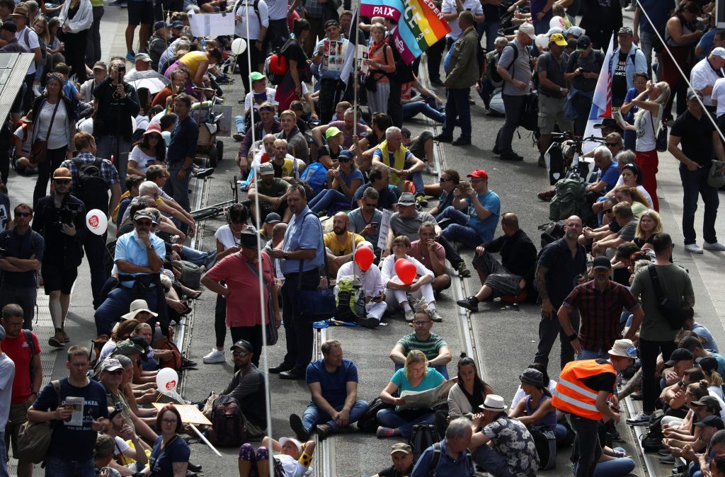 People sit as they attend a rally against the government's restrictions following the coronavirus disease (COVID-19) outbreak, in Berlin, Germany, August 29, 2020. REUTERS/Christian Mang
