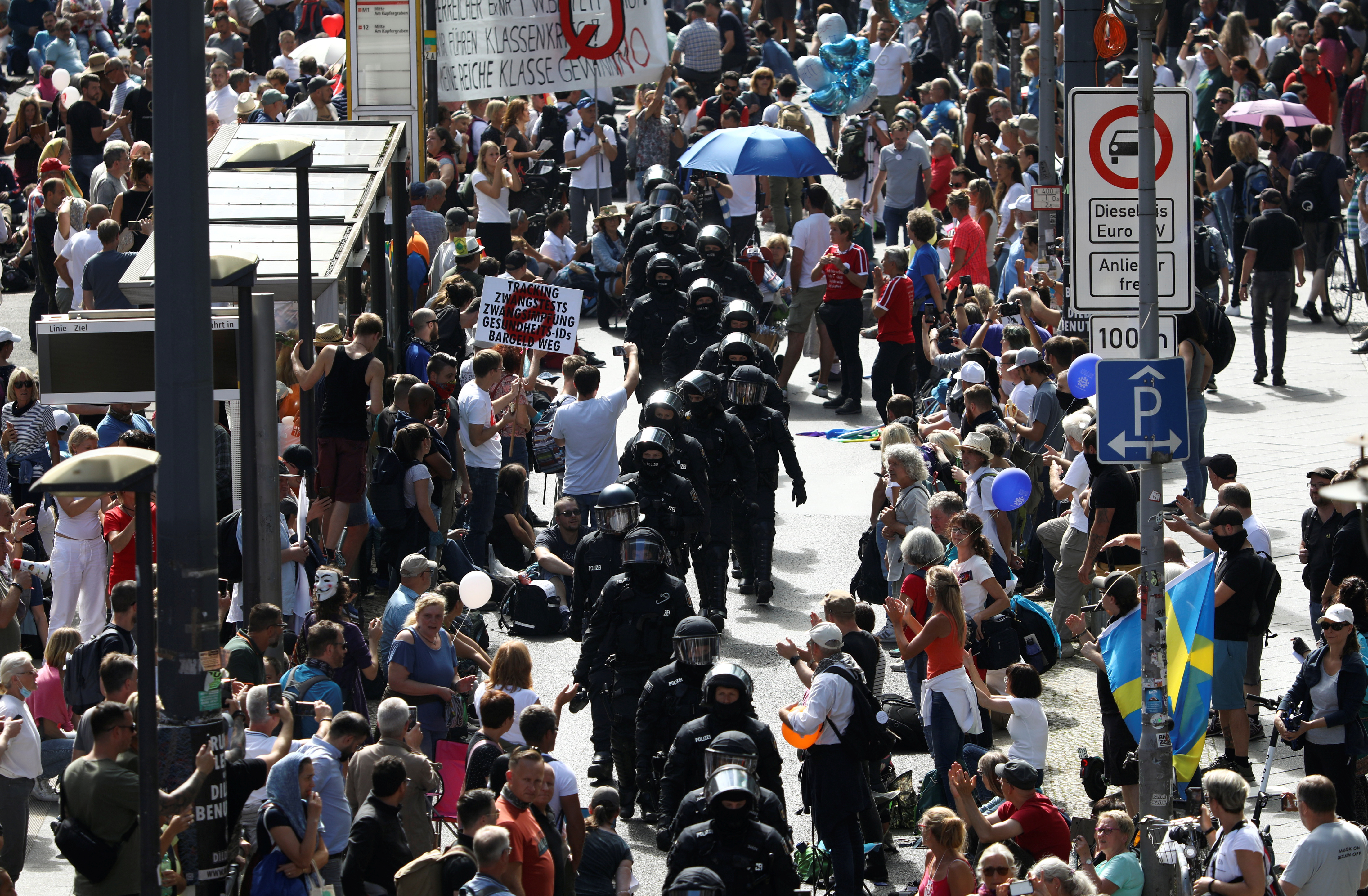 Police officers walk by people as they attend a rally against the government's restrictions following the coronavirus disease (COVID-19) outbreak, in Berlin, Germany, August 29, 2020. REUTERS/Christian Mang