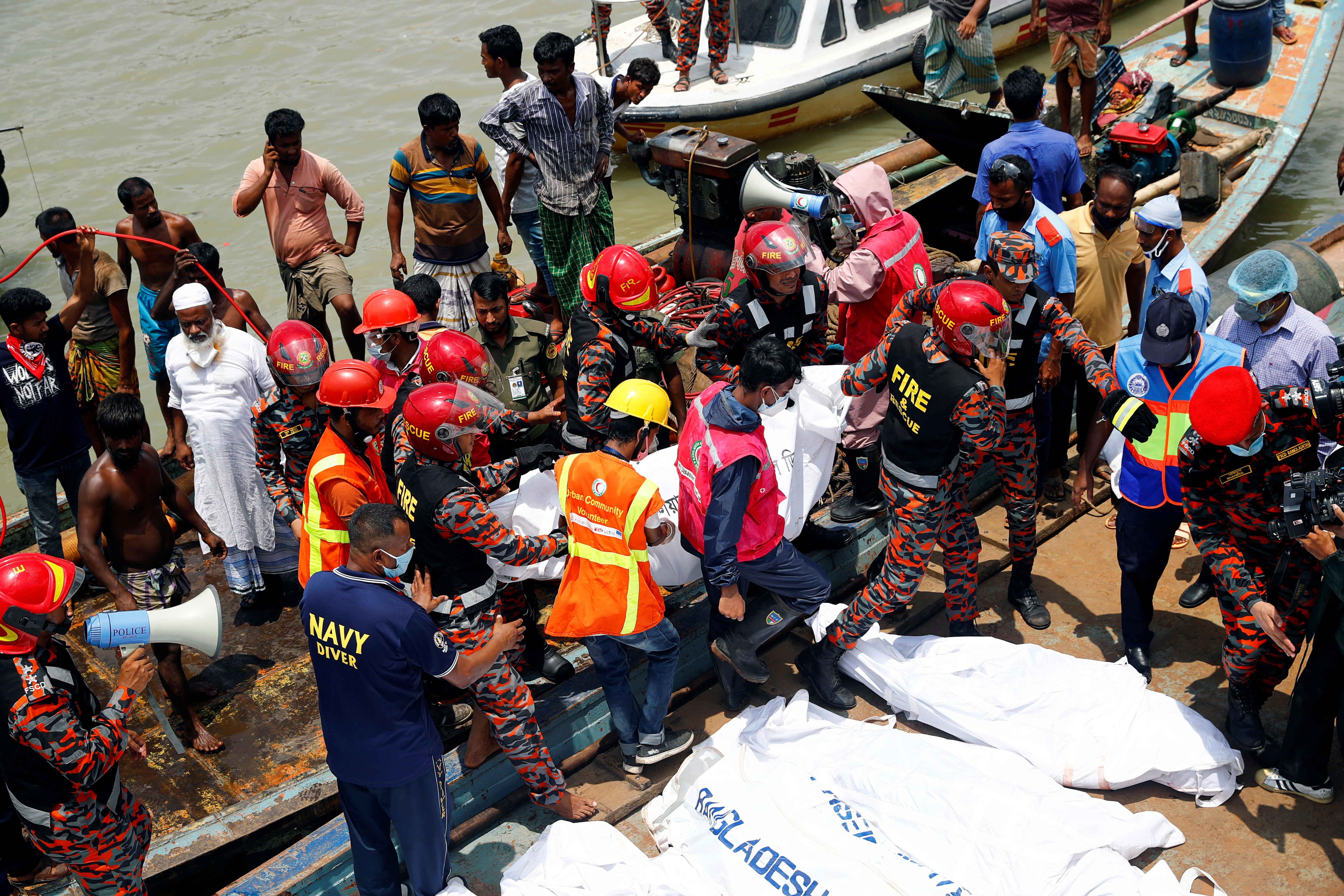 Security personnel move a body of a victim after a passenger ferry capsized in the river Buriganga in Dhaka