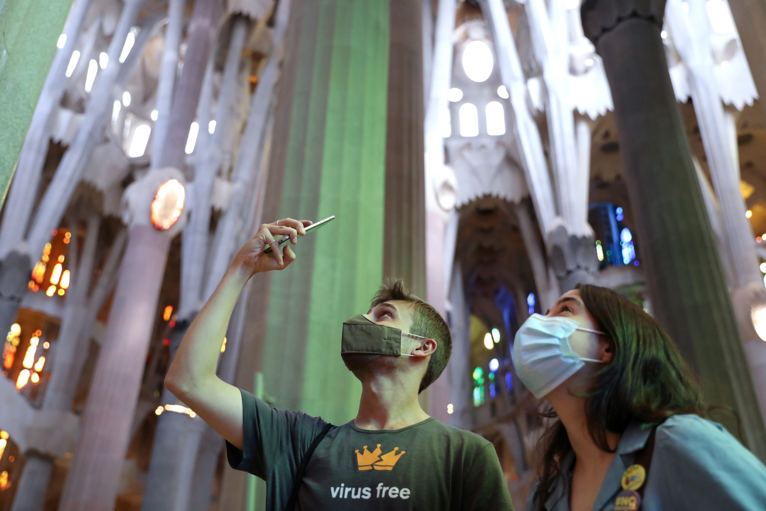 A man uses his phone as health workers, police officers and NGO staff members with their families visit the Sagrada Familia basilica as it reopens following the coronavirus disease (COVID-19) outbreak, in Barcelona, Spain, July 4, 2020. REUTERS/Nacho Doce