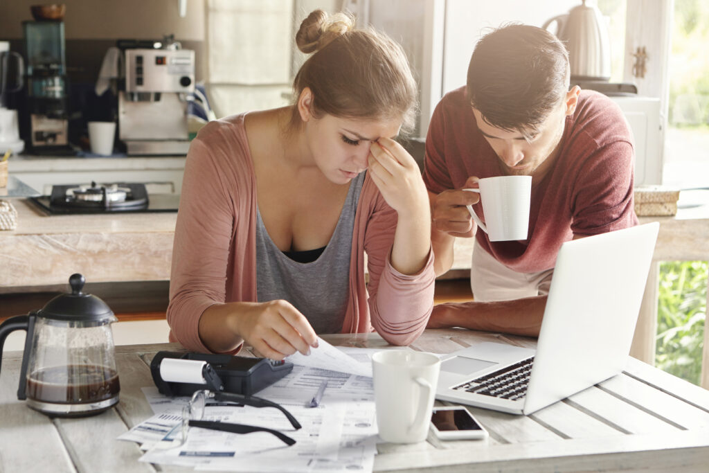 1761827526-couple-facing-financial-problem-failing-pay-loan-bank-stressed-woman-managing-family-budget-making-calculations-using-laptop-calculator-her-husband-standing-her-with-cup-tea-1024x683.jpg