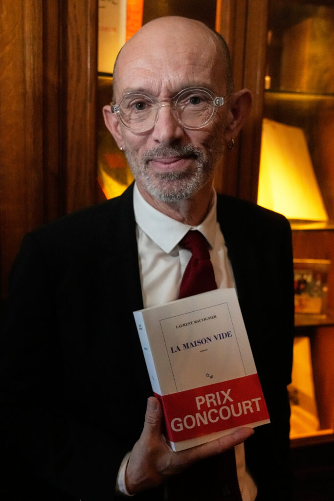 French novelist Laurent Mauvignier holds his book "La Maison Vide" (The Empty House) after receiving the famed literary Goncourt Prize,Tuesday, Nov. 4, 2025 in Paris. (AP Photo/Michel Euler)
