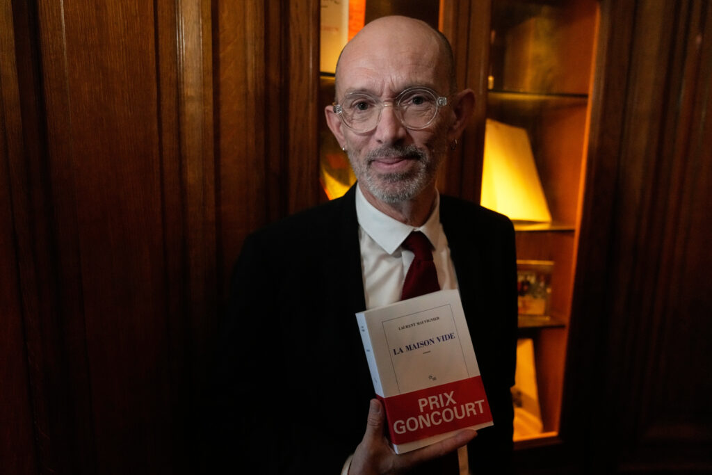 French novelist Laurent Mauvignier holds his book "La Maison Vide" (The Empty House) after receiving the famed literary Goncourt Prize,Tuesday, Nov. 4, 2025 in Paris. (AP Photo/Michel Euler)