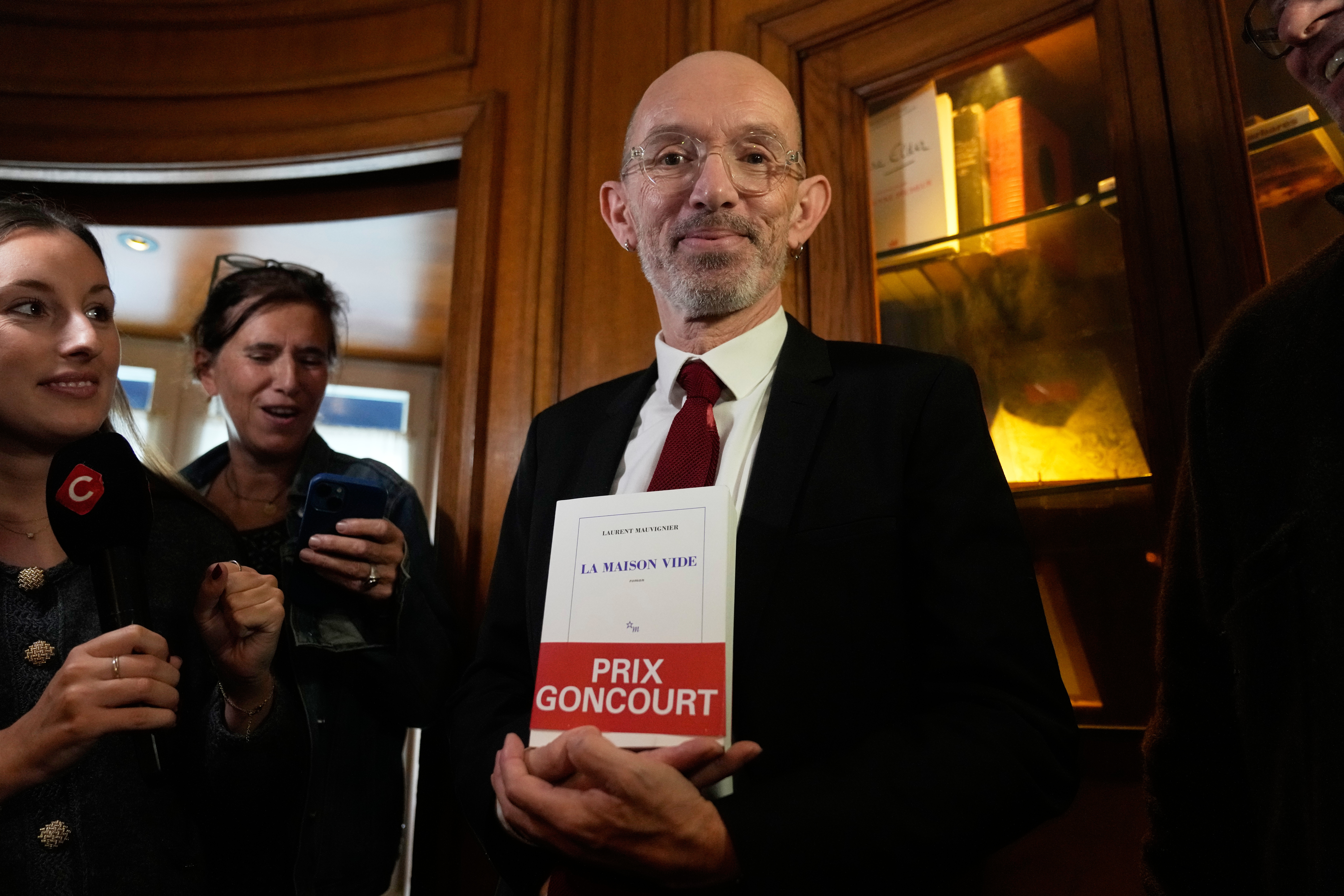 French novelist Laurent Mauvignier holds his book "La Maison Vide" (The Empty House) after receiving the famed literary Goncourt Prize,Tuesday, Nov. 4, 2025 in Paris. (AP Photo/Michel Euler)