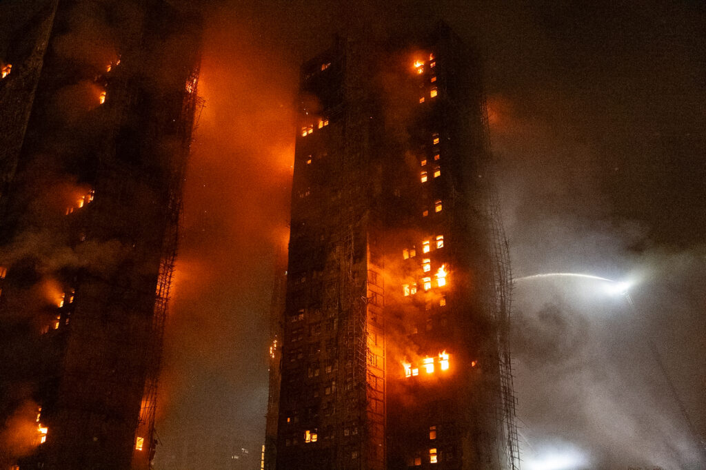 Firefighters try to extinguish a fire that broke out at Wang Fuk Court, a residential estate in the Tai Po district of Hong Kong's New Territories, Wednesday, Nov. 26 2025. (AP Photo/Chan Long Hei)