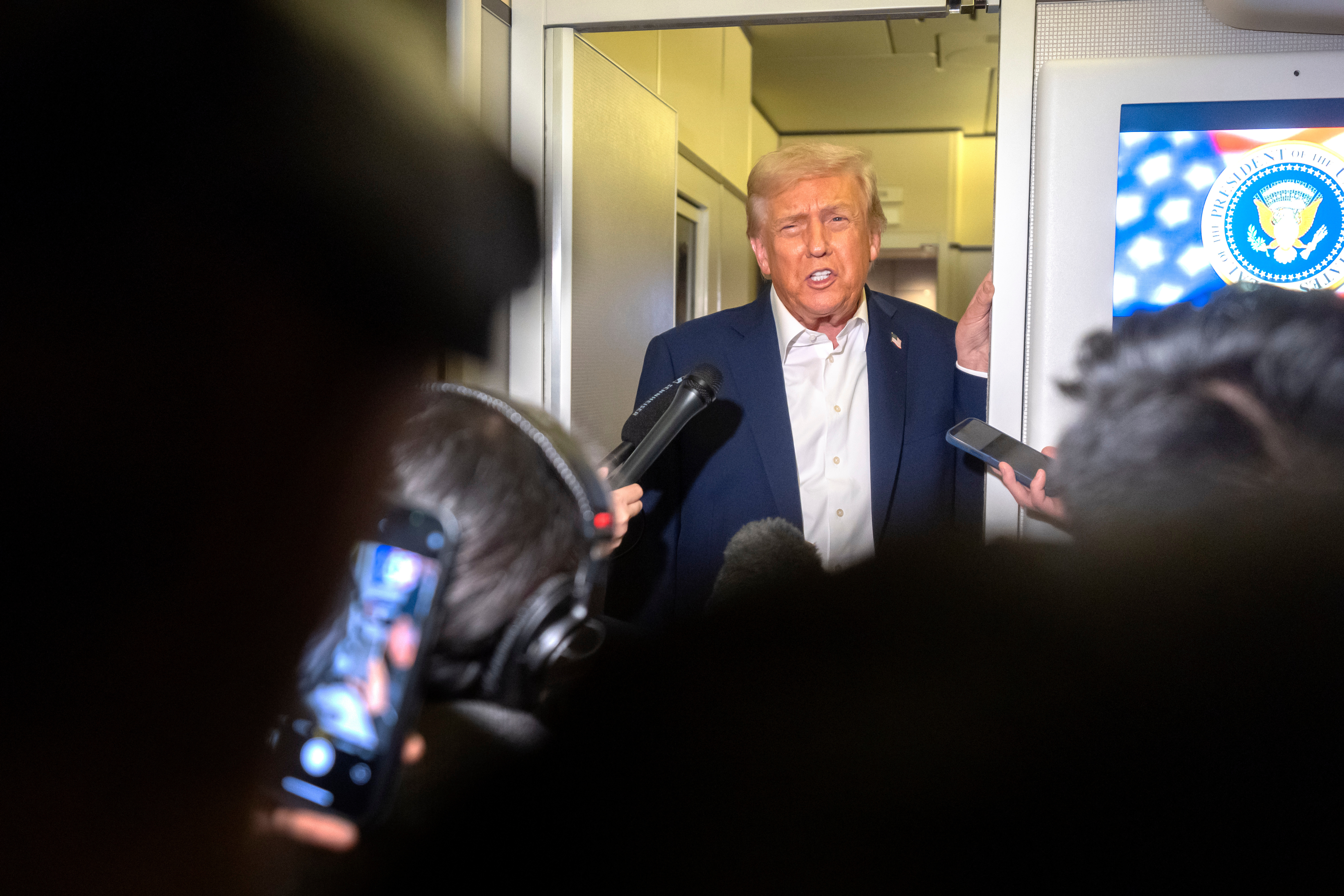 President Donald Trump speaks to reporters aboard Air Force One en route to Asia, Friday, Oct. 24, 2025. (AP Photo/Mark Schiefelbein)