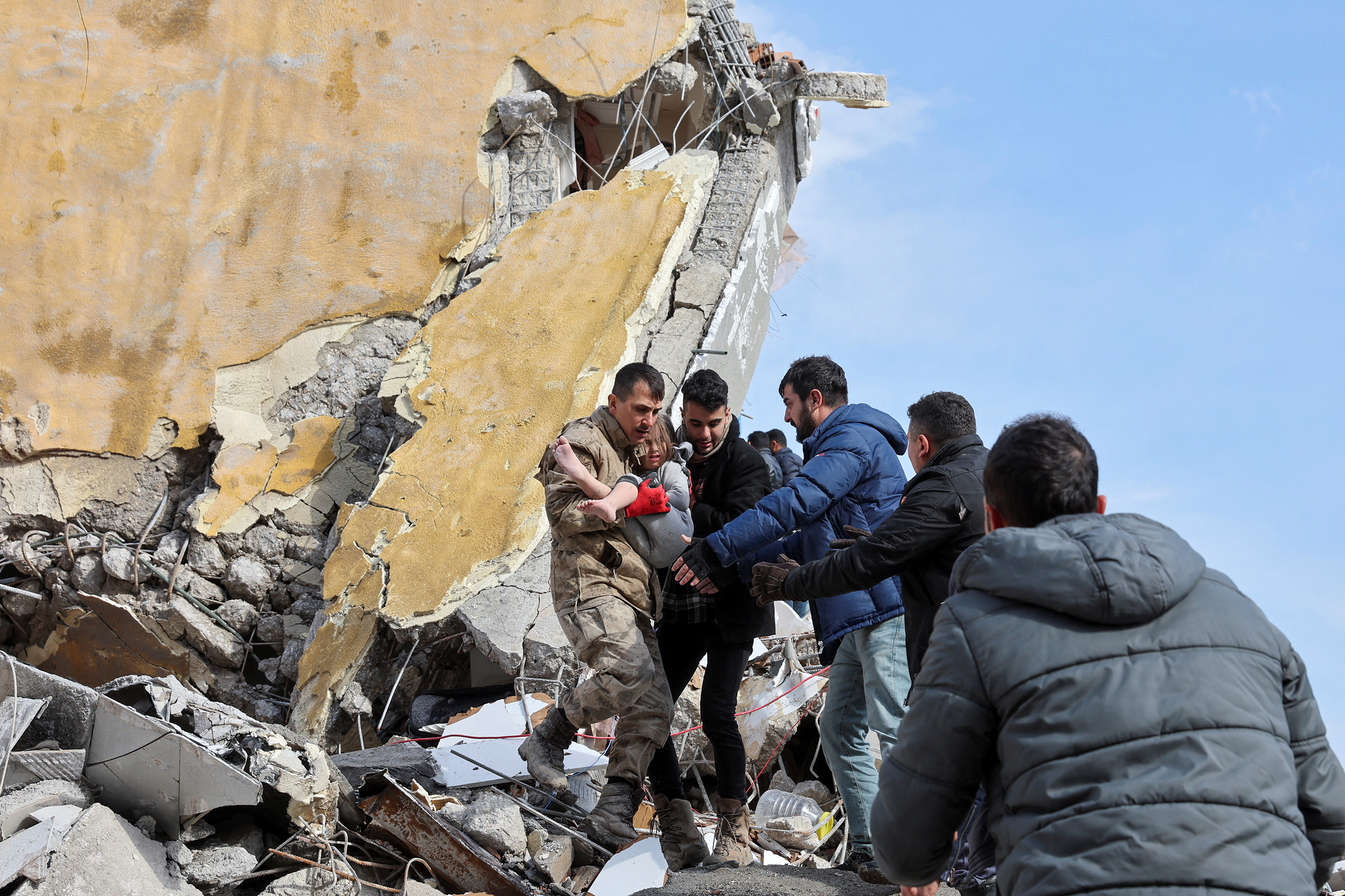 Muhammet Ruzgar, 5, is carried out by rescuers from the site of a damaged building, following an earthquake in Hatay, Turkey, February 7, 2023. REUTERS/Umit Bektas