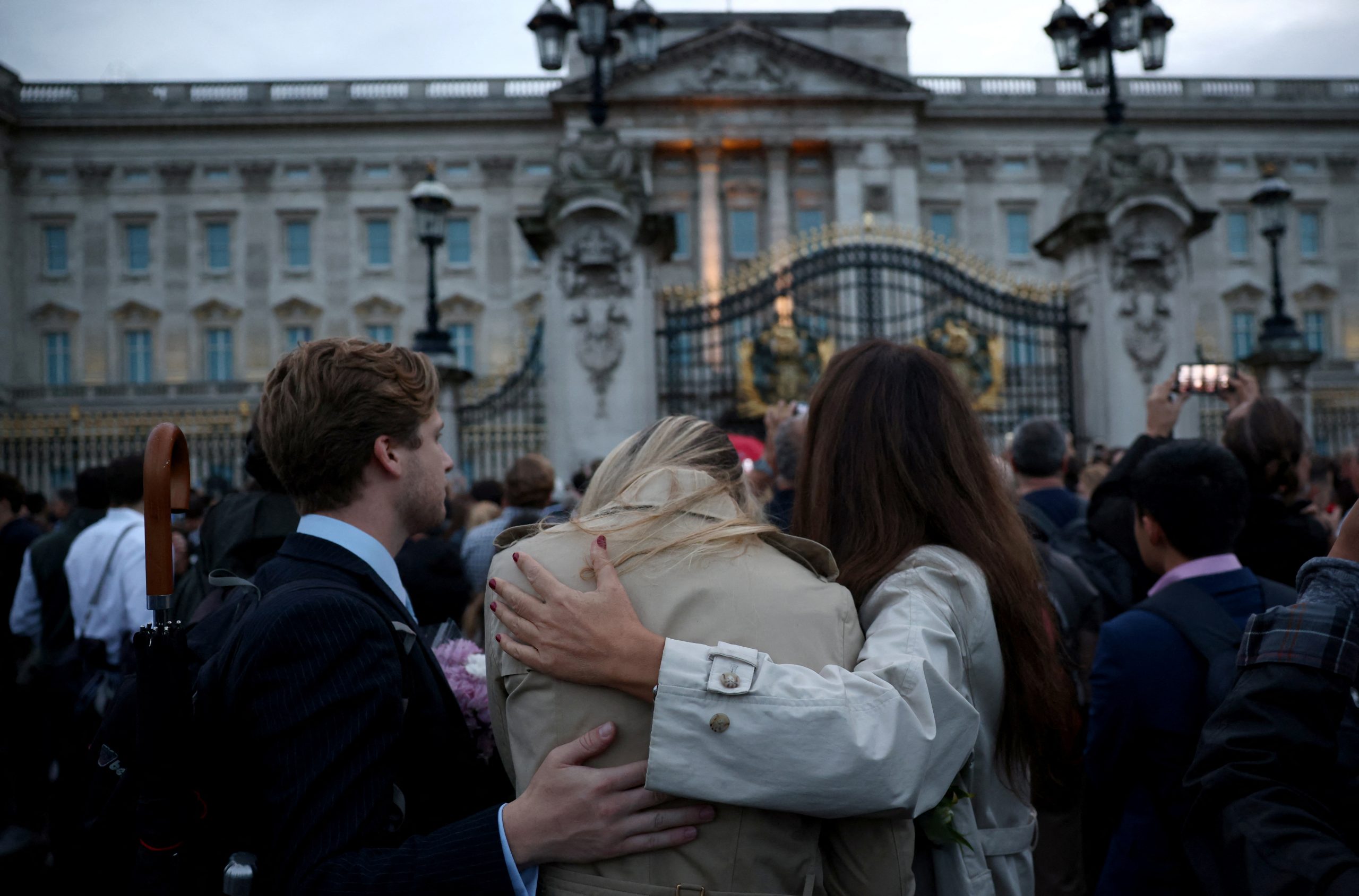 People react outside the Buckingham Palace, after Queen Elizabeth, Britain's longest-reigning monarch and the nation's figurehead for seven decades, died aged 96, according to Buckingham Palace, in London, Britain September 8, 2022. REUTERS/Henry Nicholls